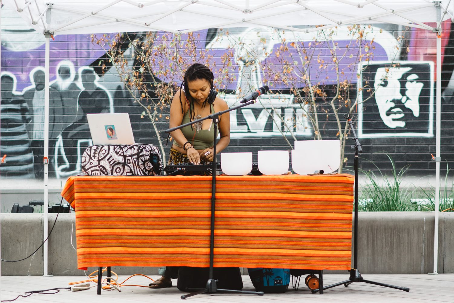 Graffiti art decorates walls behind orange wooden benches in an urban setting.