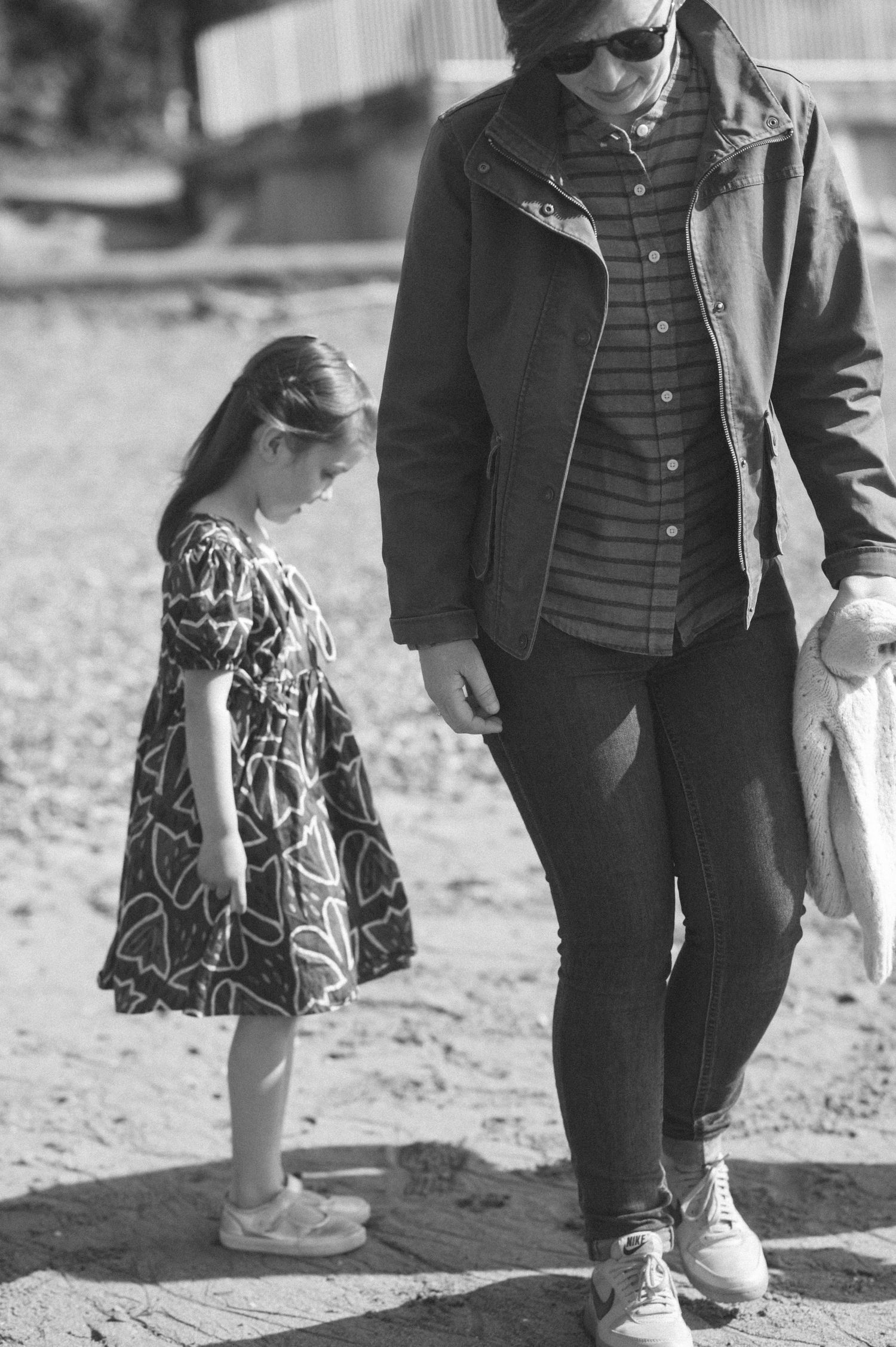 Black and white photo of people walking together on a beach path.