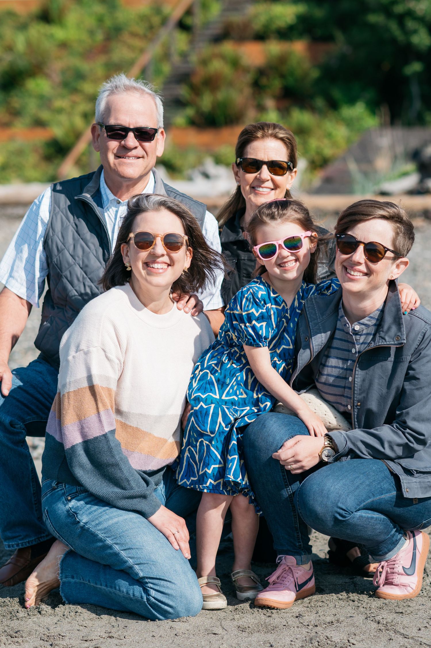Casual group photo of people sitting together on a sunny beach.