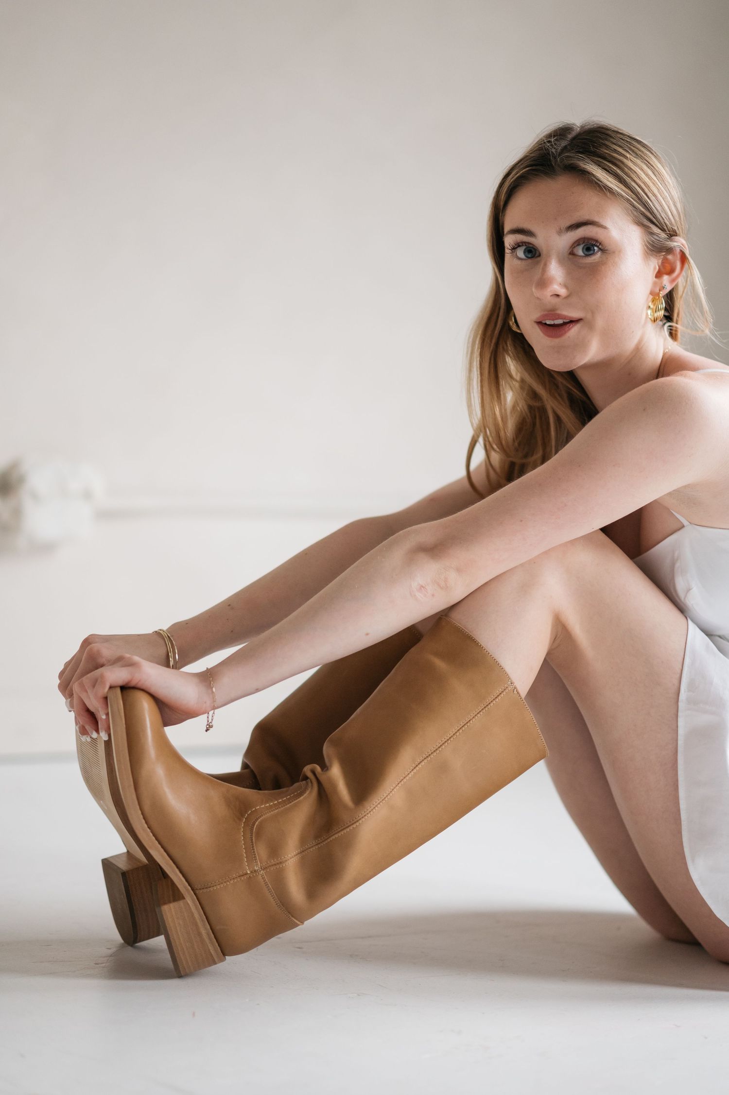 Artistic fashion photo series featuring tan boots and minimalist styling against white background.