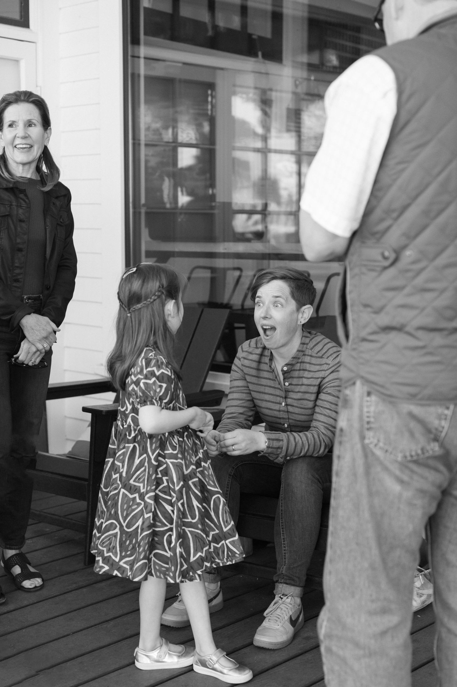 A casual gathering of people on a porch having an animated discussion.