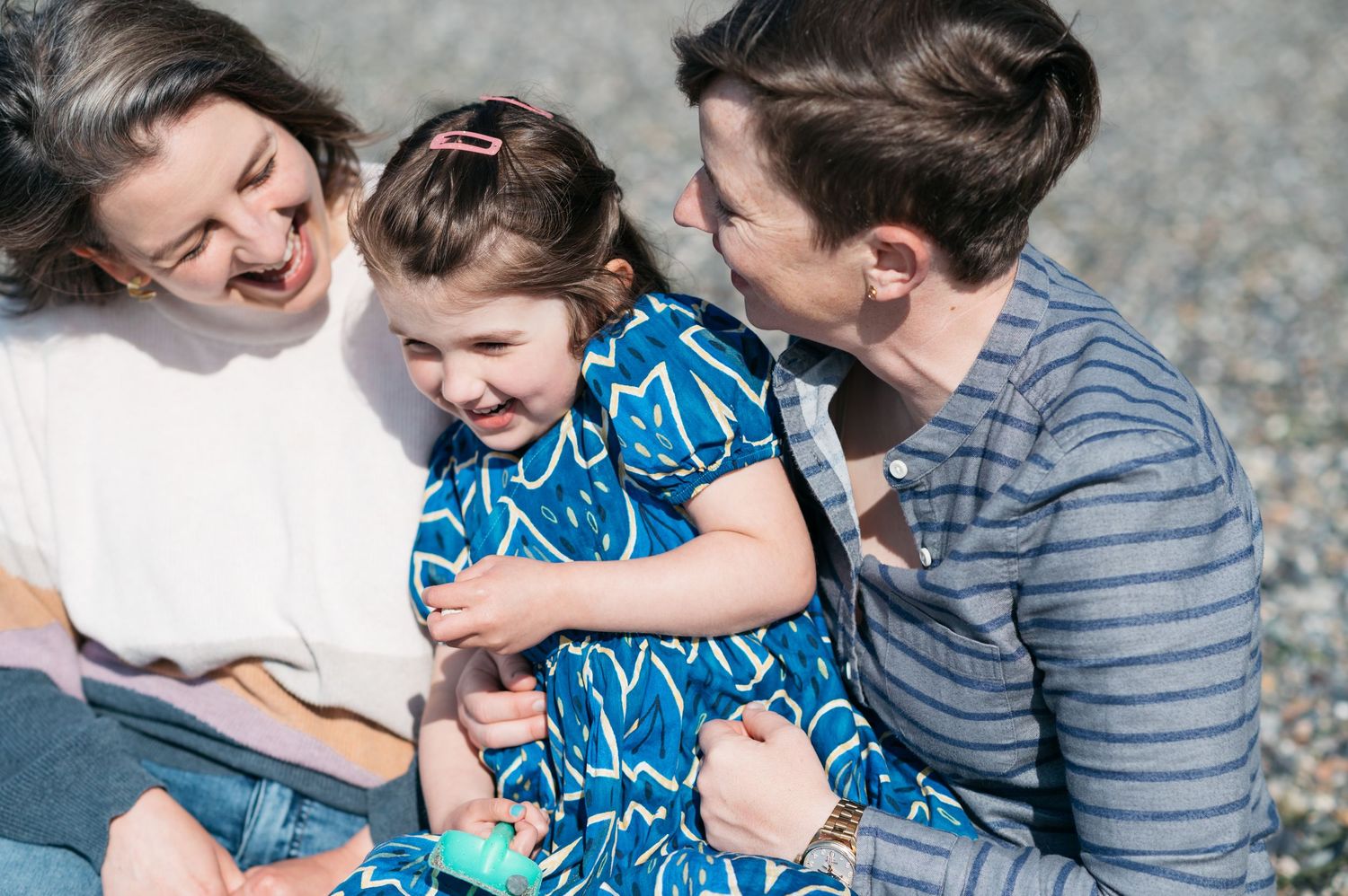 A joyful family moment shared on a rocky beach.