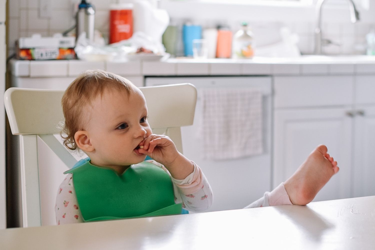 A series of photos showing a baby in a kitchen exploring different facial expressions and poses.