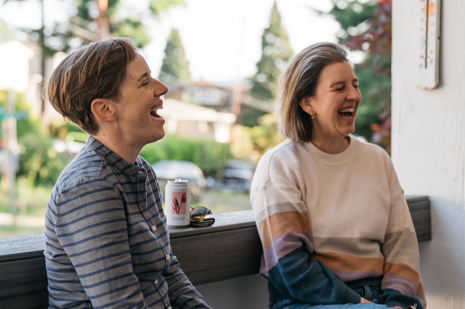 People sharing laughs while sitting together on an outdoor patio.