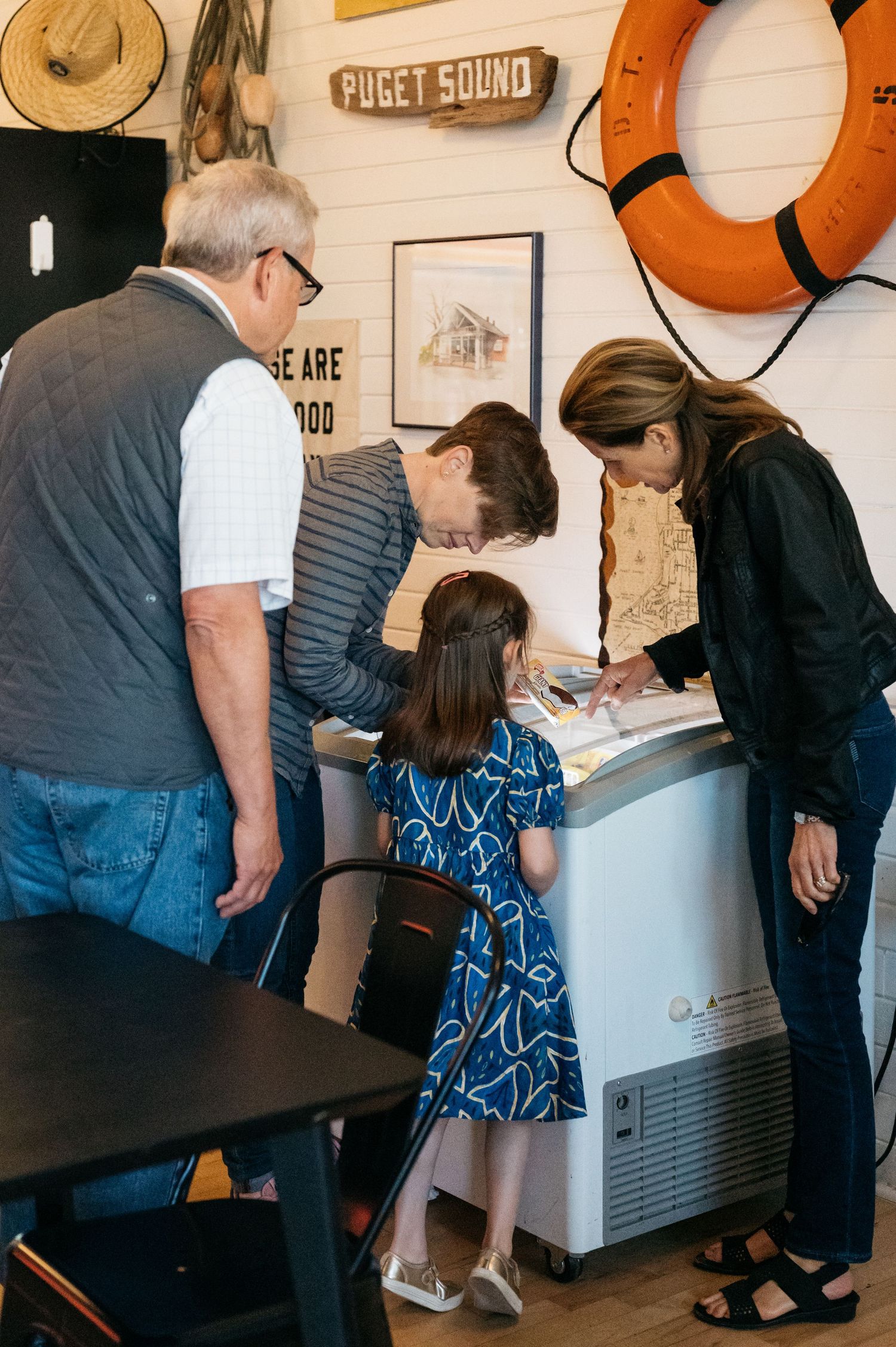 A group gathers around an ice machine in a coffee shop.