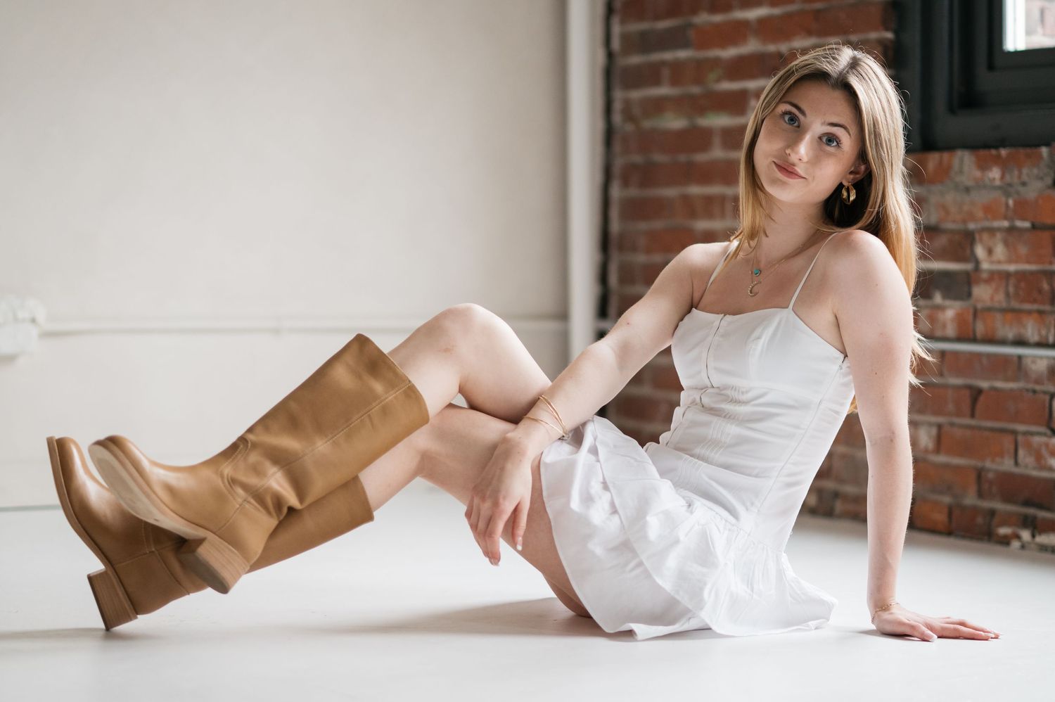Series of artistic portraits showing person in white top against brick wall background.