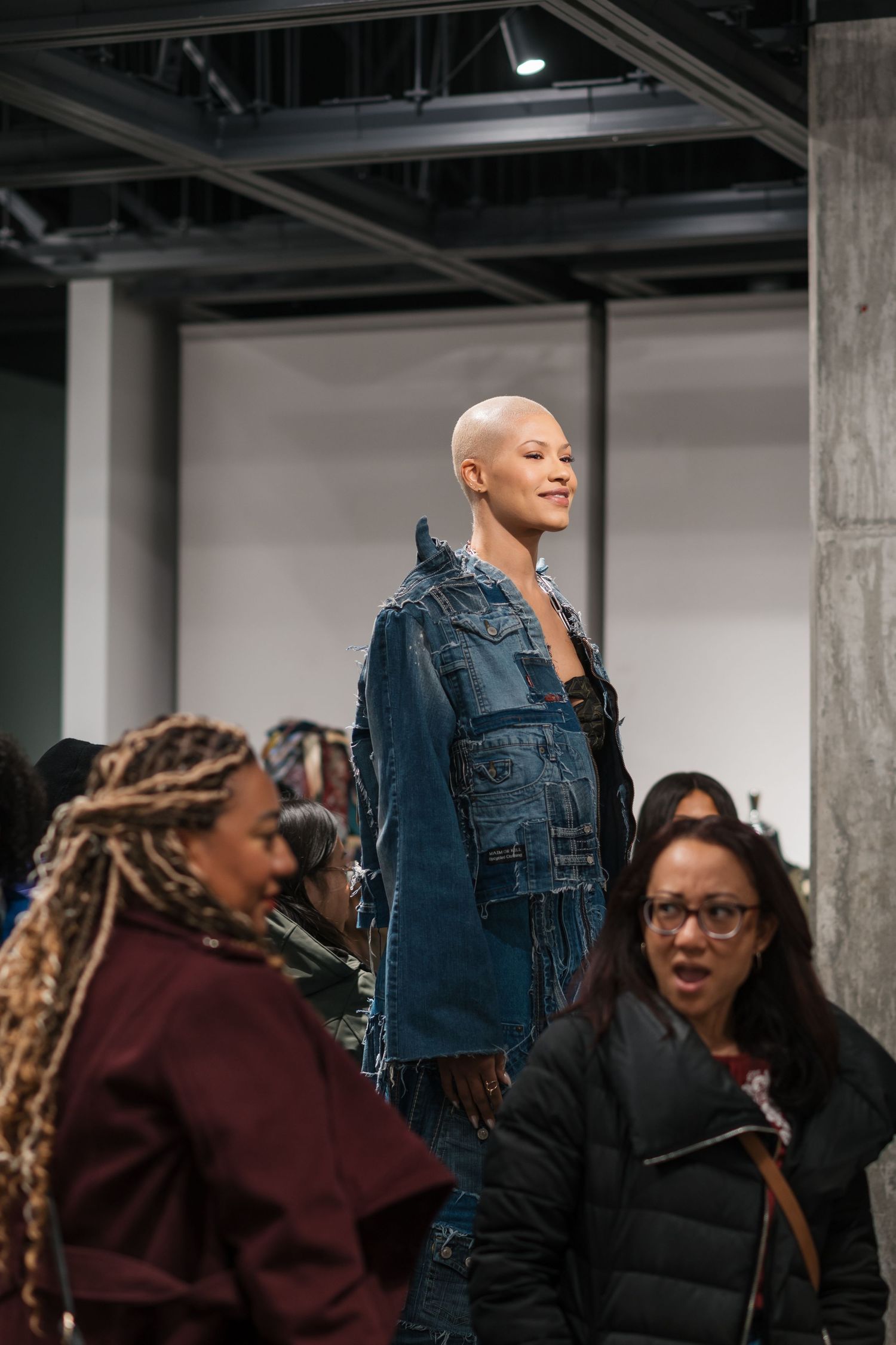 People gathered in an industrial space wearing denim and casual attire.
