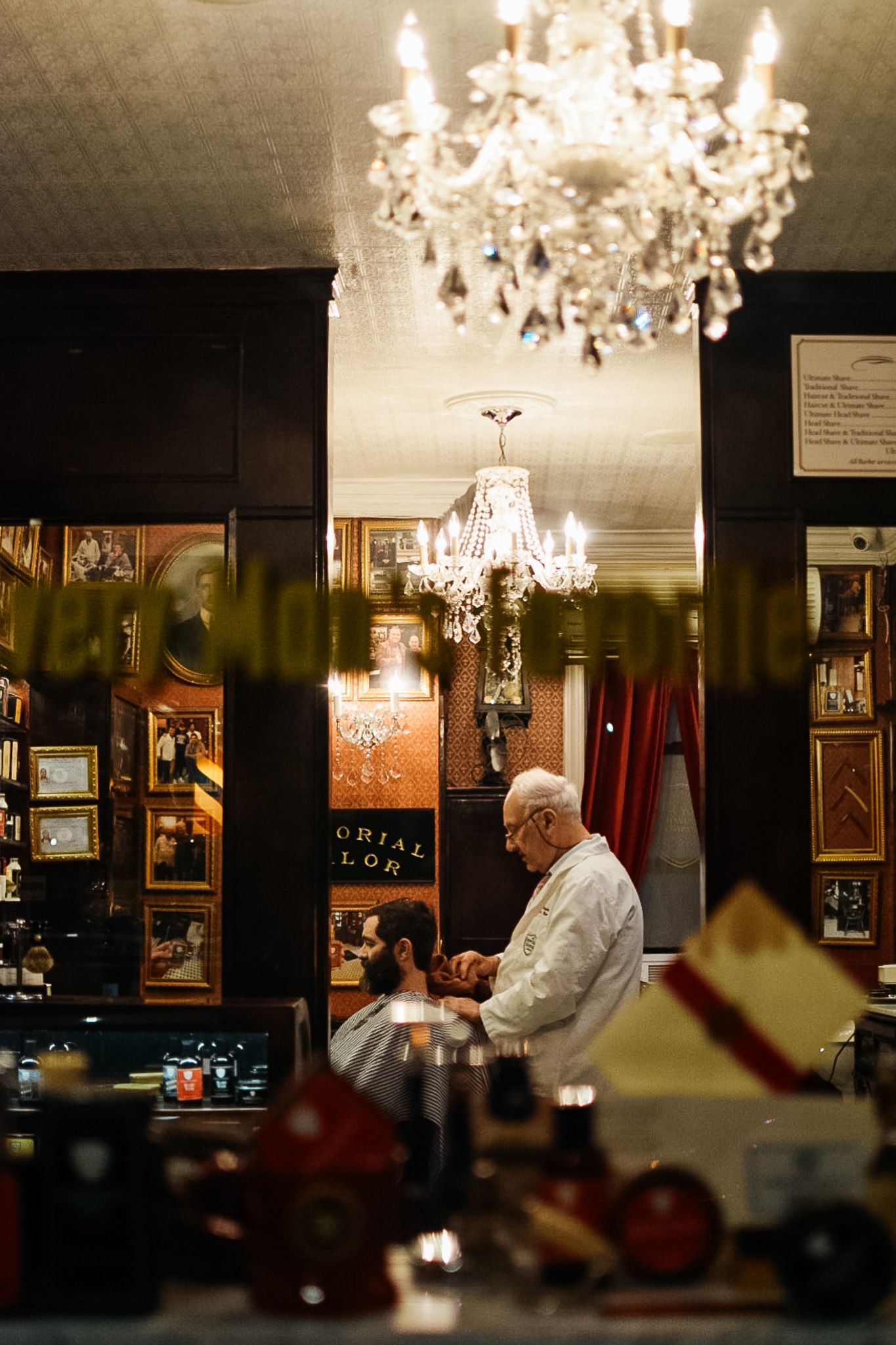 Elegant crystal chandelier hanging in a dimly lit vintage restaurant interior.