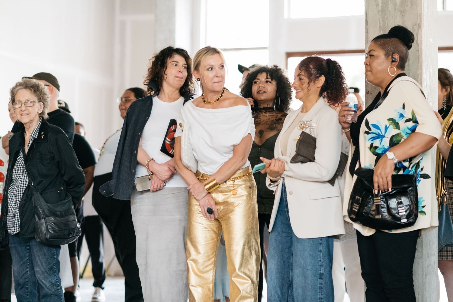 Group of people interacting and socializing in bright gallery space.