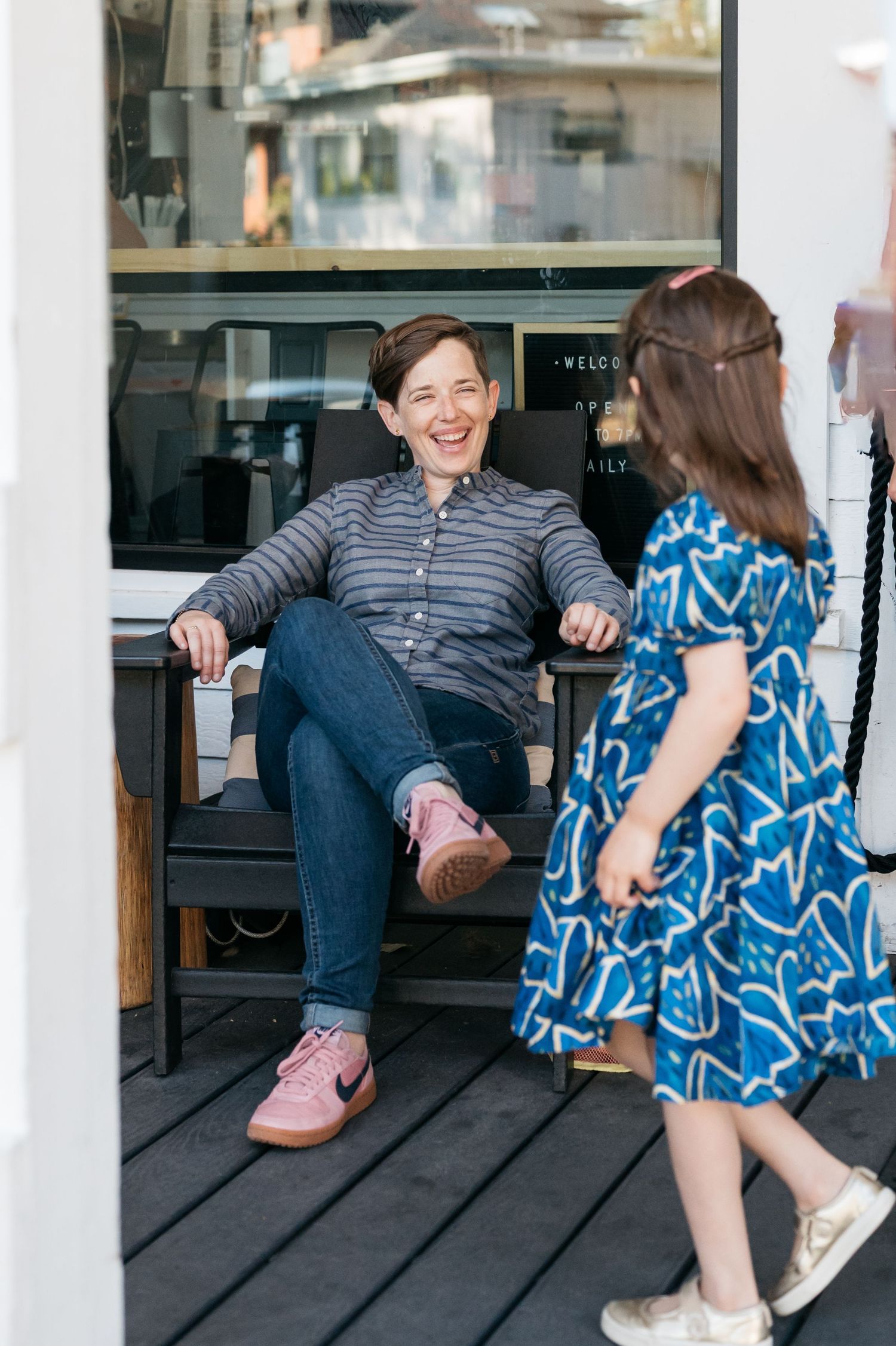 Two people having an animated conversation on a wooden deck.