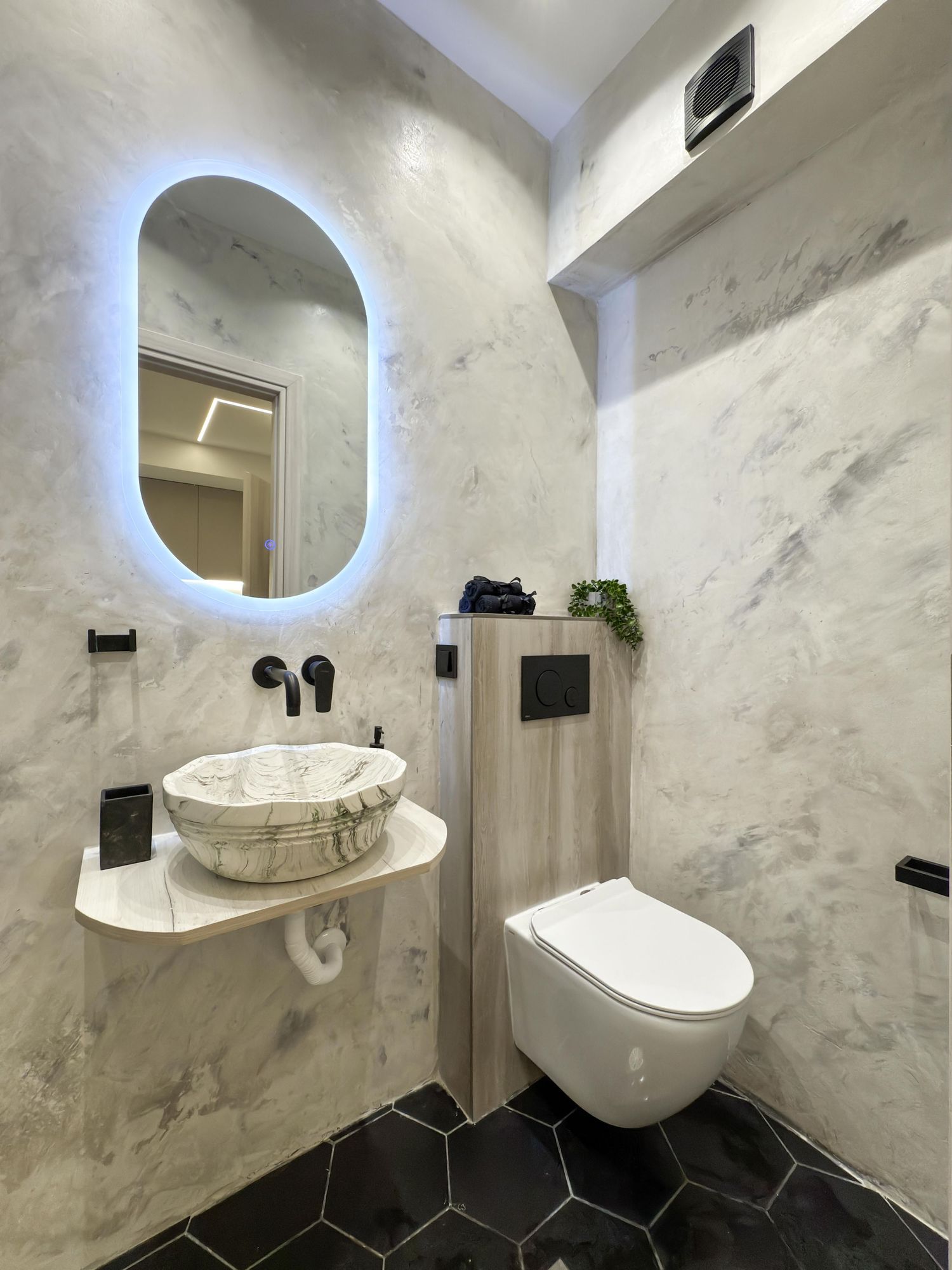 Καθαρό μπάνιο με marble πάγκους και μοντέρνα λεπτομέρεια
