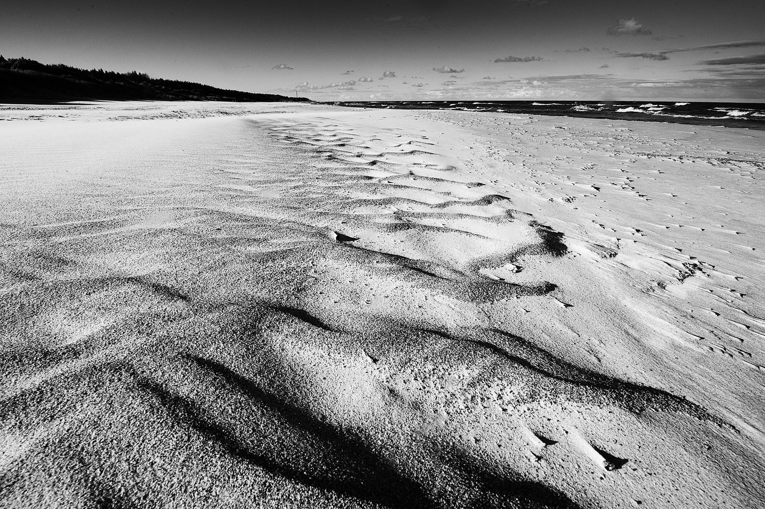 Svart-hvitt bilde av sandmønstre på en strand i Vestland. Detaljert naturfotografering som viser teksturer og kystlandskap.