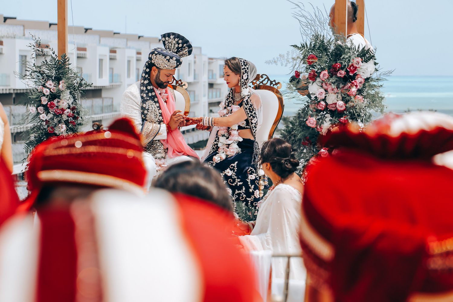 Red and white floral decorations adorn an outdoor wedding ceremony space.