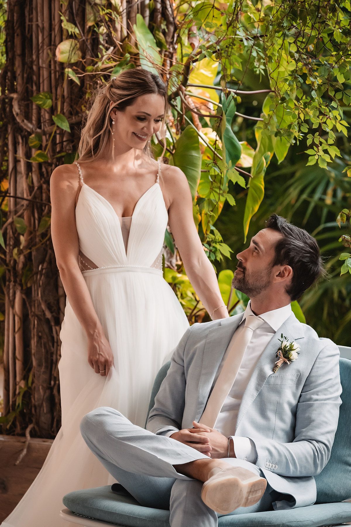 An intimate moment captured on a modern patio chair with tropical foliage in the background.