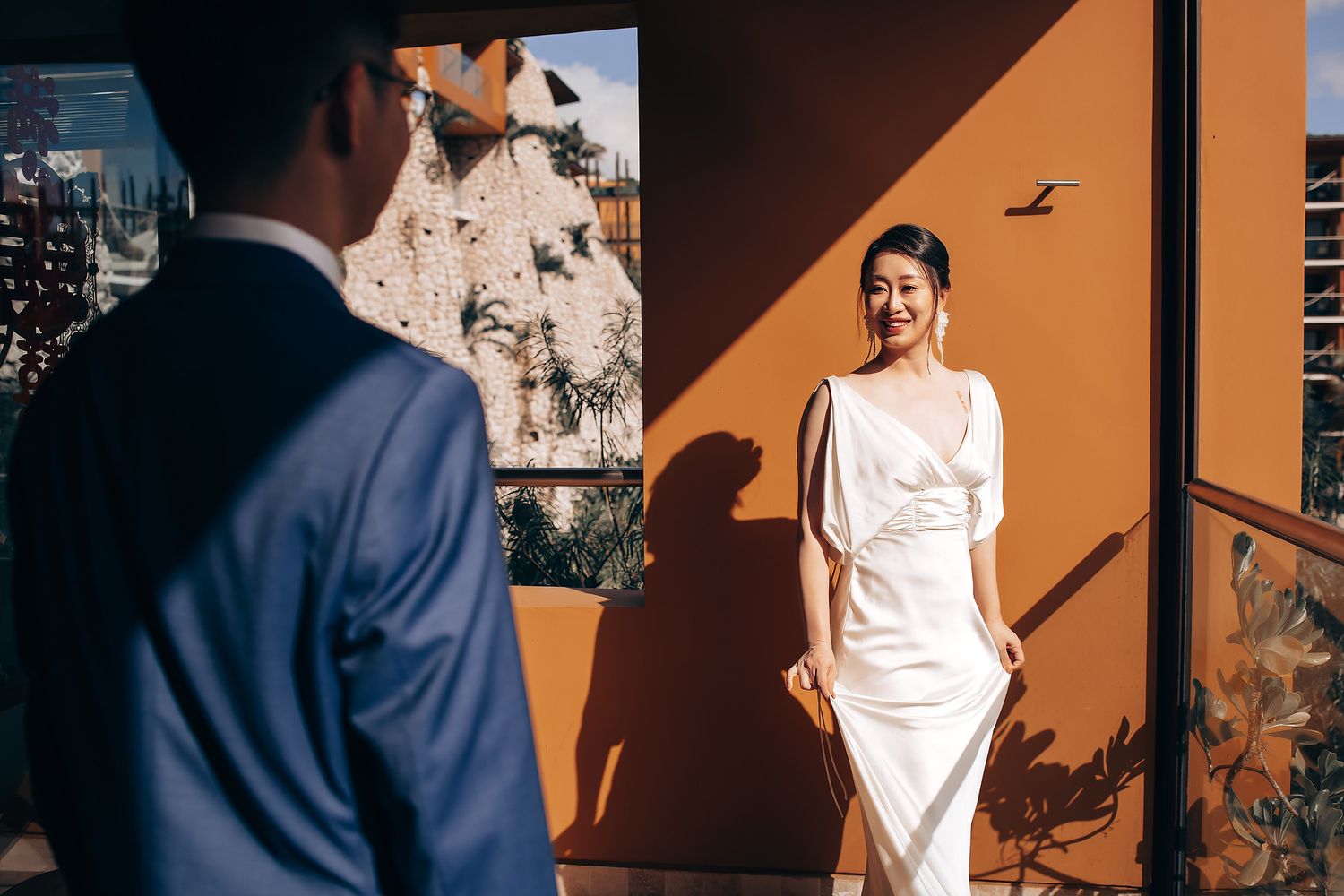 Elegant wedding photo shoot with dramatic shadows and sunlight on a terrace.