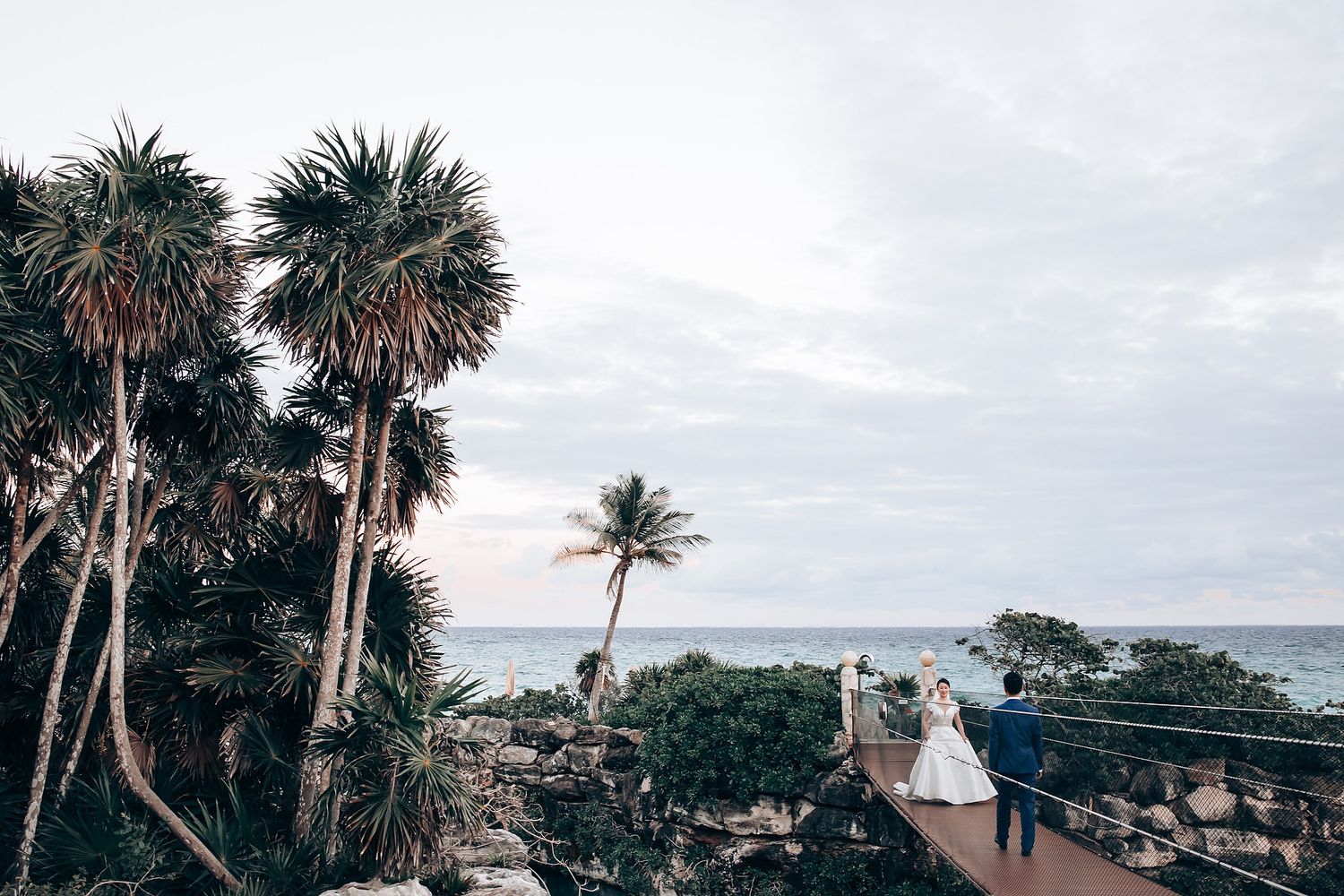 Coastal wedding venue with palm trees and ocean views during golden hour.