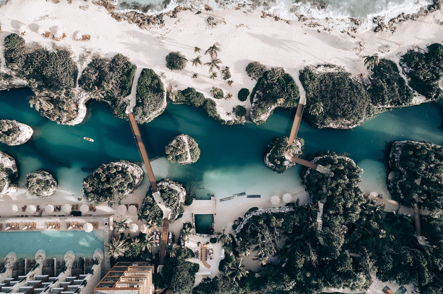 Aerial view of turquoise waters with boats and coastal landscape.
