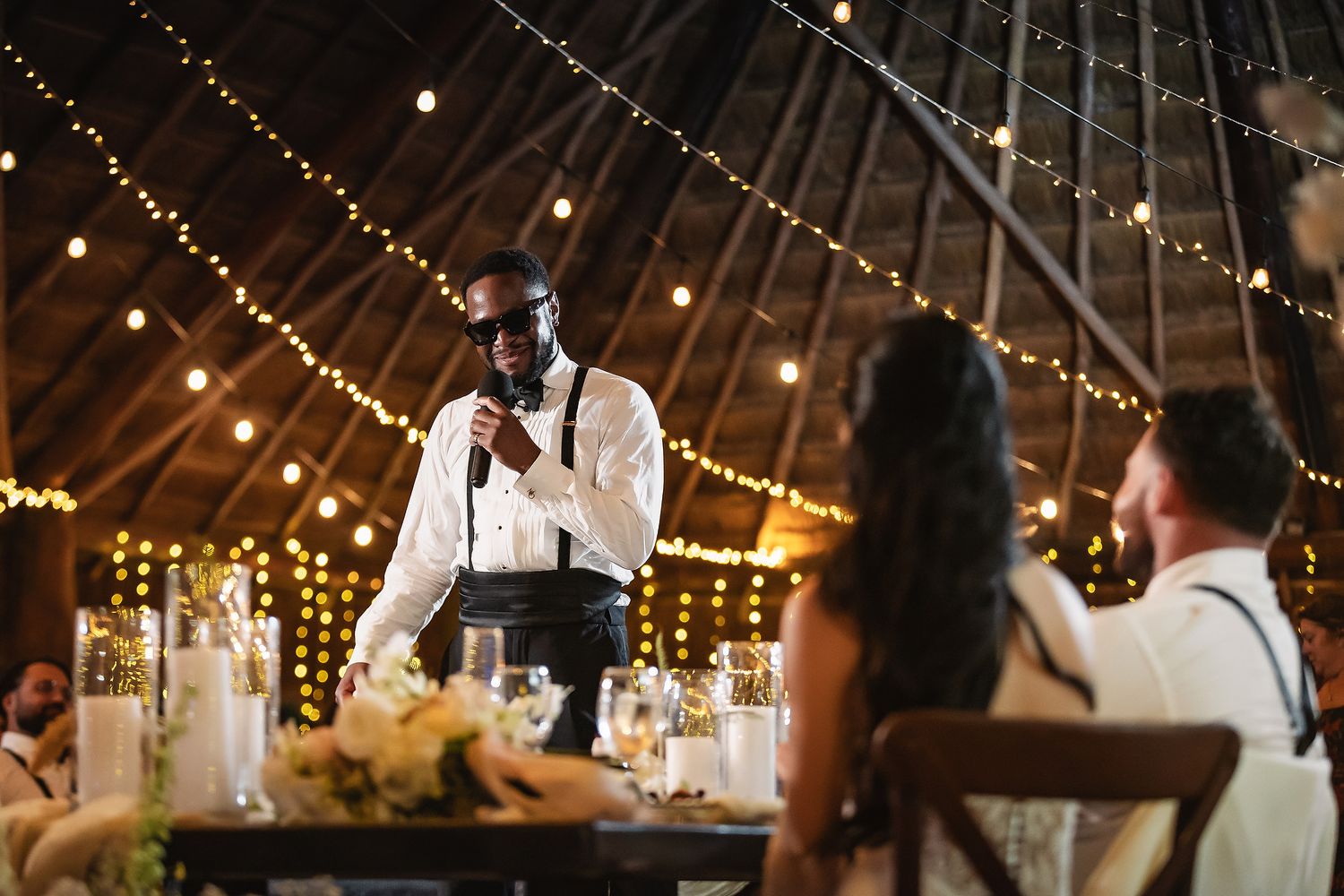 Wedding celebration venue with romantic string lights illuminating the rustic wooden ceiling.