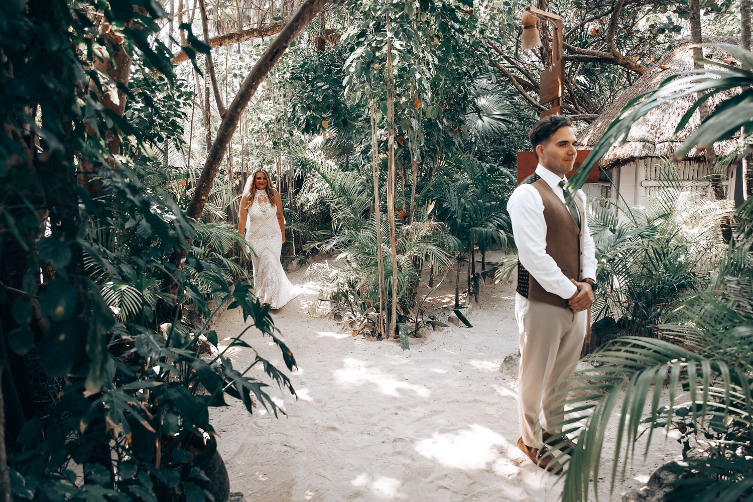 A couple stands in a lush garden setting during an intimate outdoor wedding ceremony.