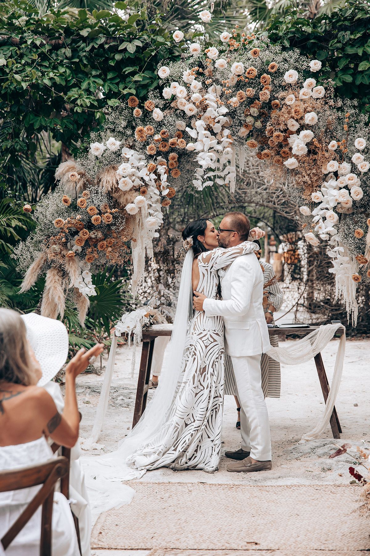 A romantic outdoor wedding ceremony with floral arrangements and natural decor in a garden setting.