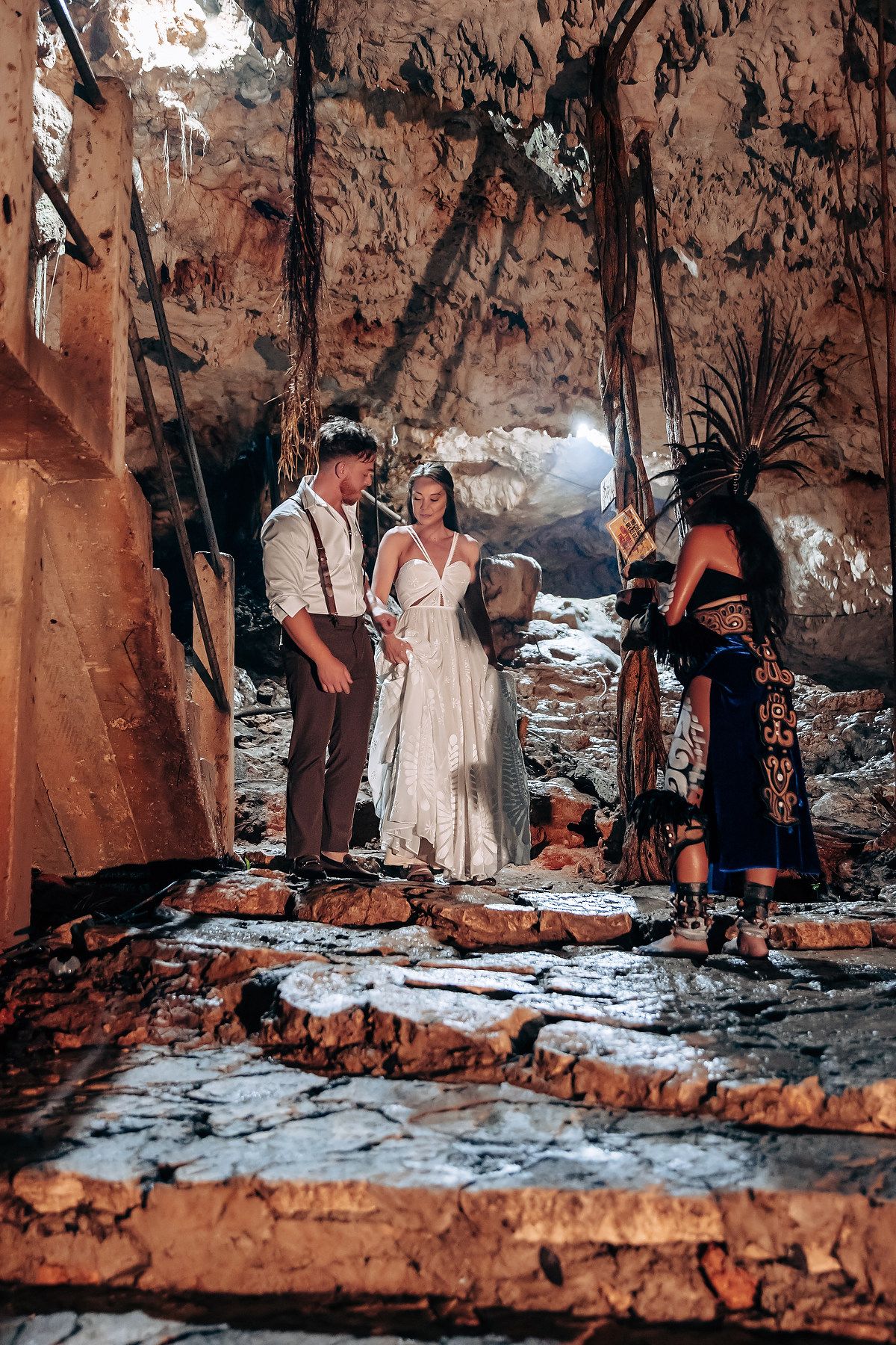 Couple exploring a scenic cave formation with dramatic rock walls and natural lighting.
