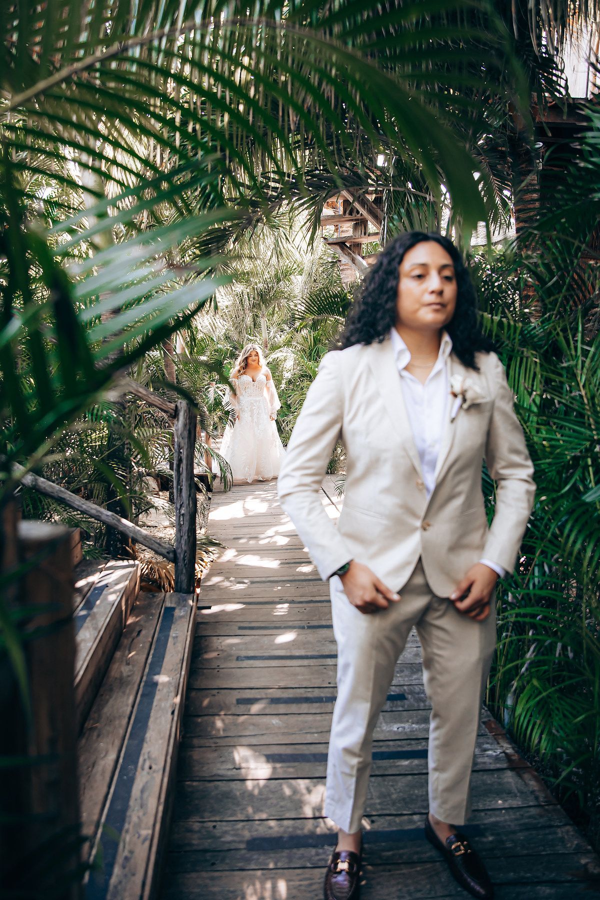 A series of artistic photos showing someone in a white suit posing on wooden steps surrounded by lush palm fronds.