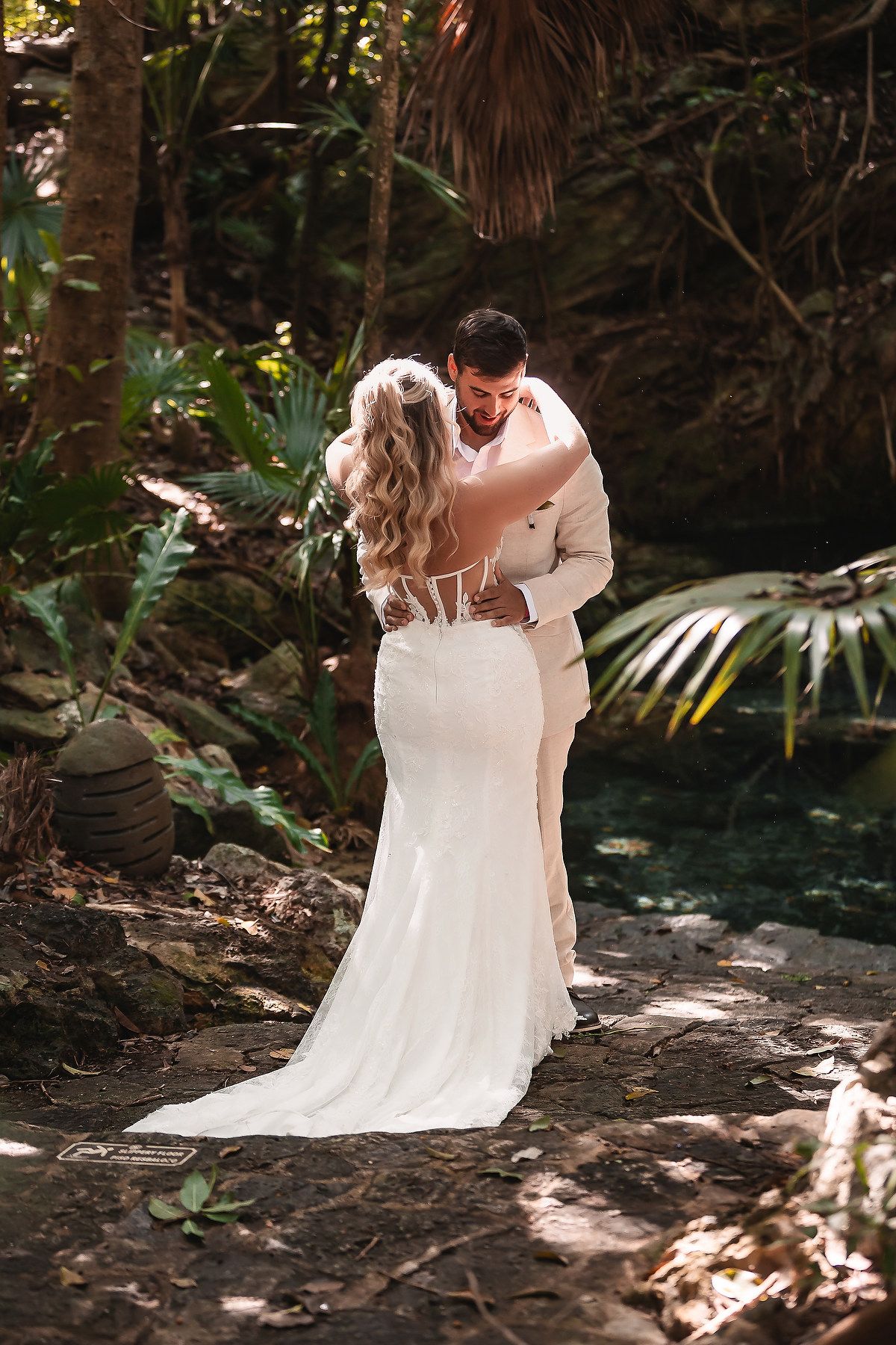Wedding photography session in a lush tropical garden setting with dappled sunlight.