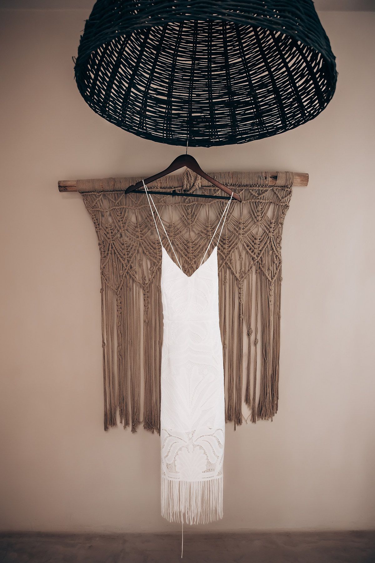 Boho-style macrame wall hangings with woven patterns displayed under black rattan pendant lights.