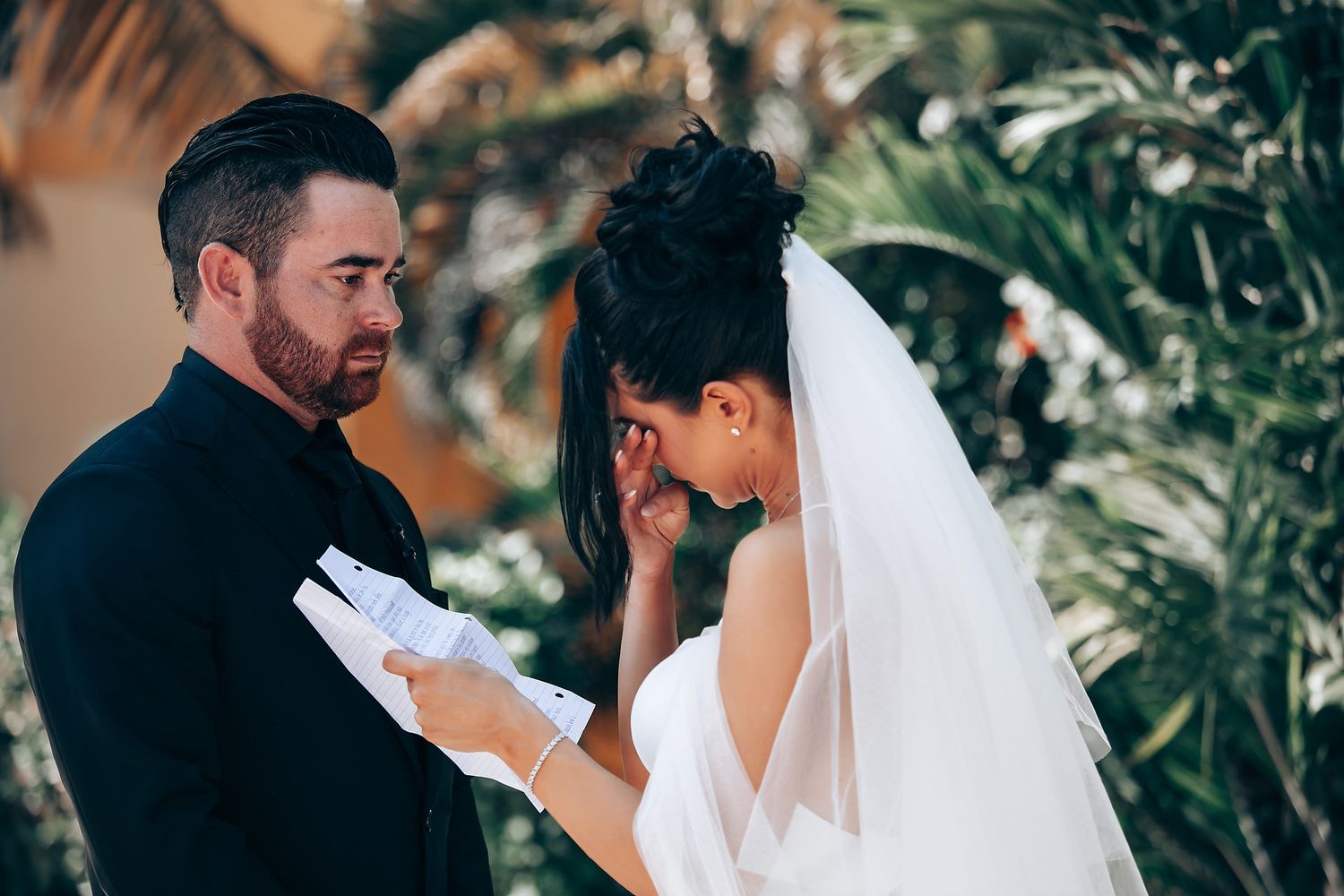 A romantic first look between newlyweds in an outdoor garden setting.
