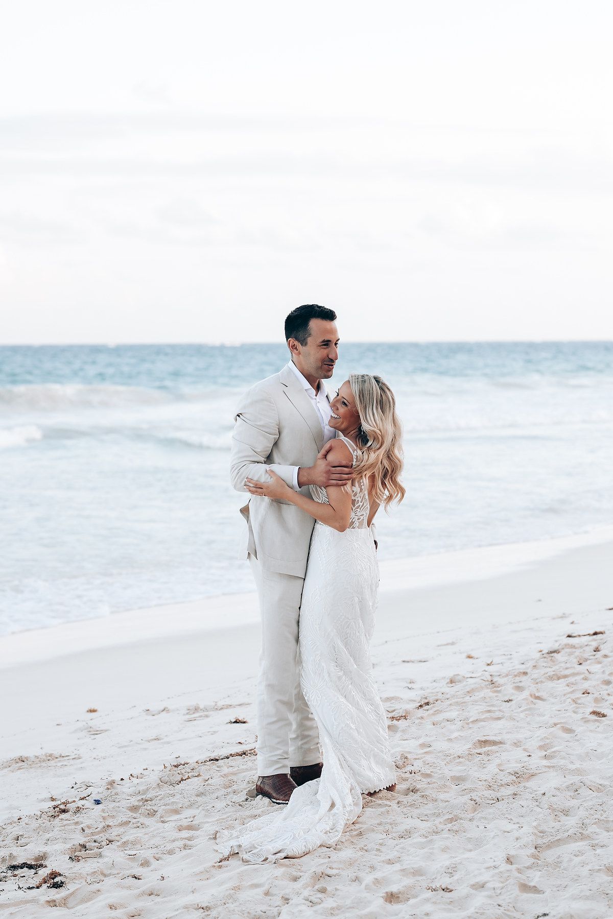 Newlyweds sharing romantic moments on a pristine white sand beach.
