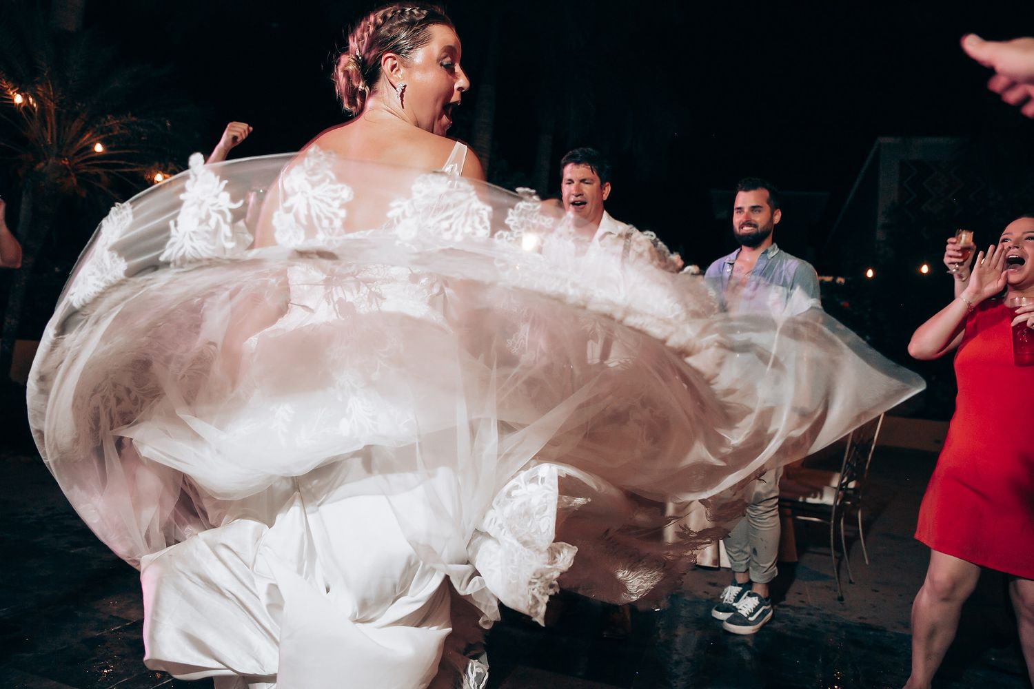 Wedding dress fabric flows elegantly during evening dance celebration.