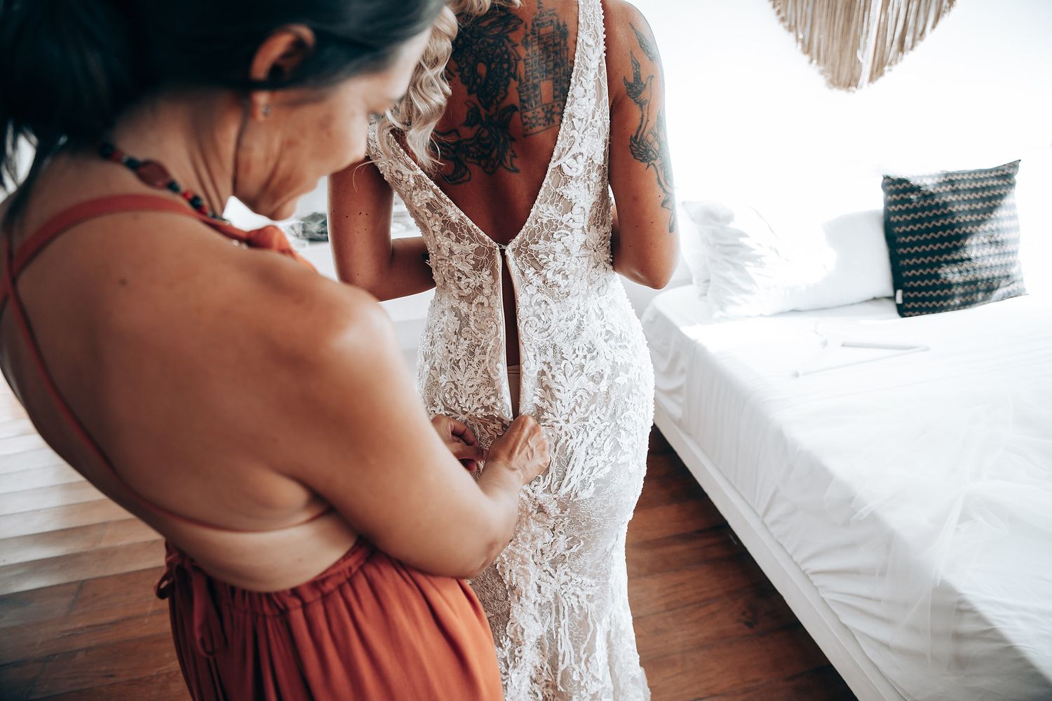 Wedding preparations in a bright room with white decor and wooden floors.