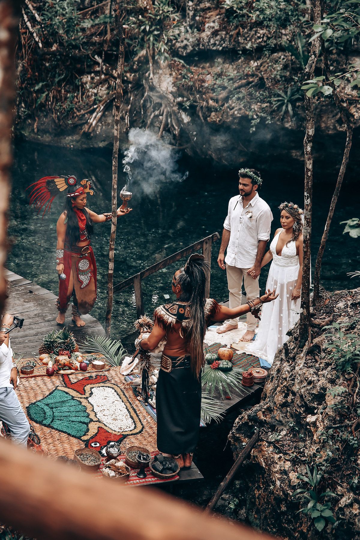 A romantic picnic setup in a forest with blankets and decorative elements creating an intimate outdoor atmosphere.