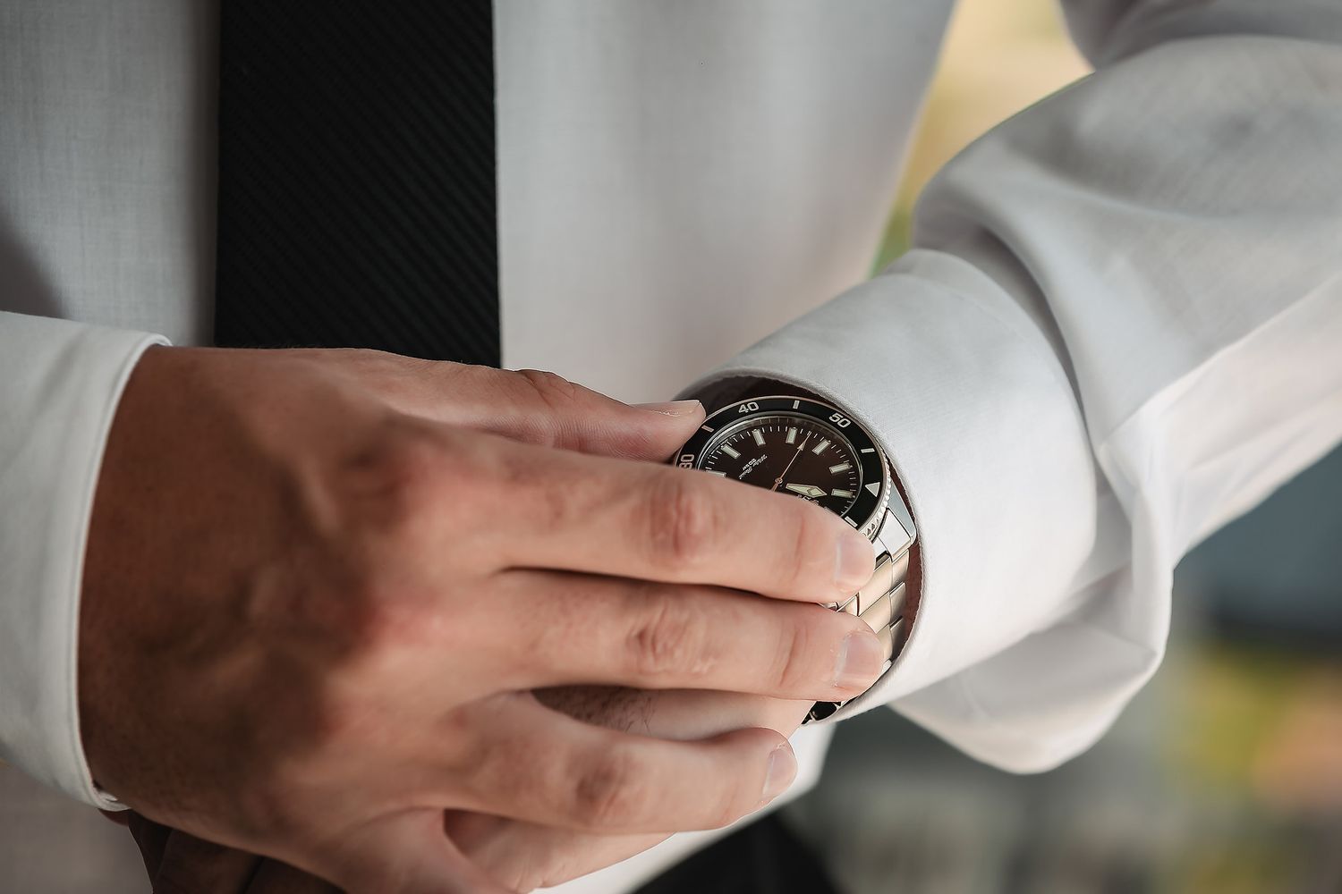 Close-up shot of hands holding a white cup against a dark background.