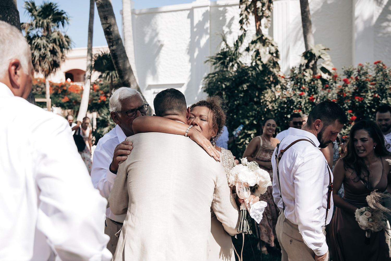 A group of people gather for a wedding ceremony outdoors.