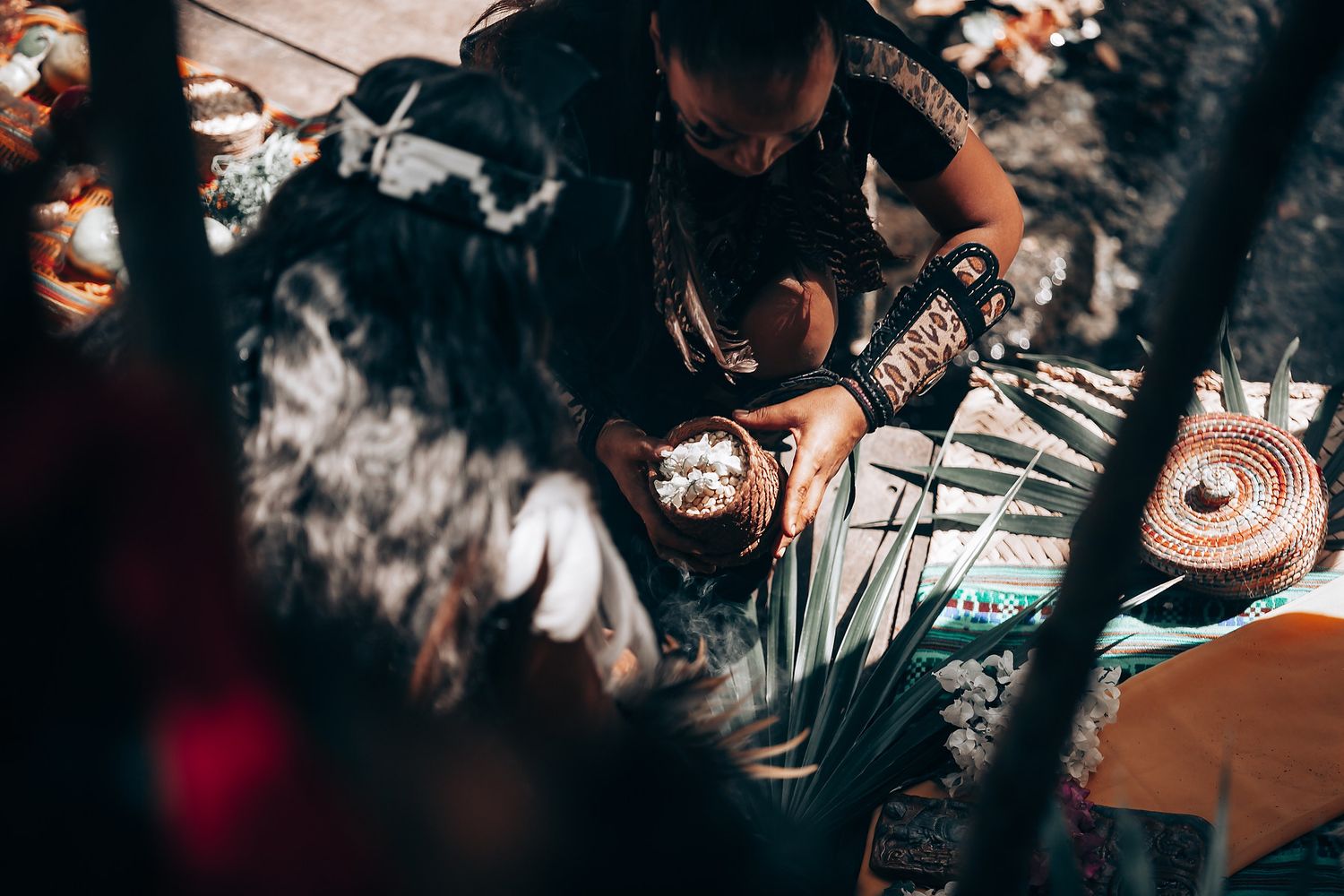 Overhead view of hands preparing ceremonial items on a wooden surface.