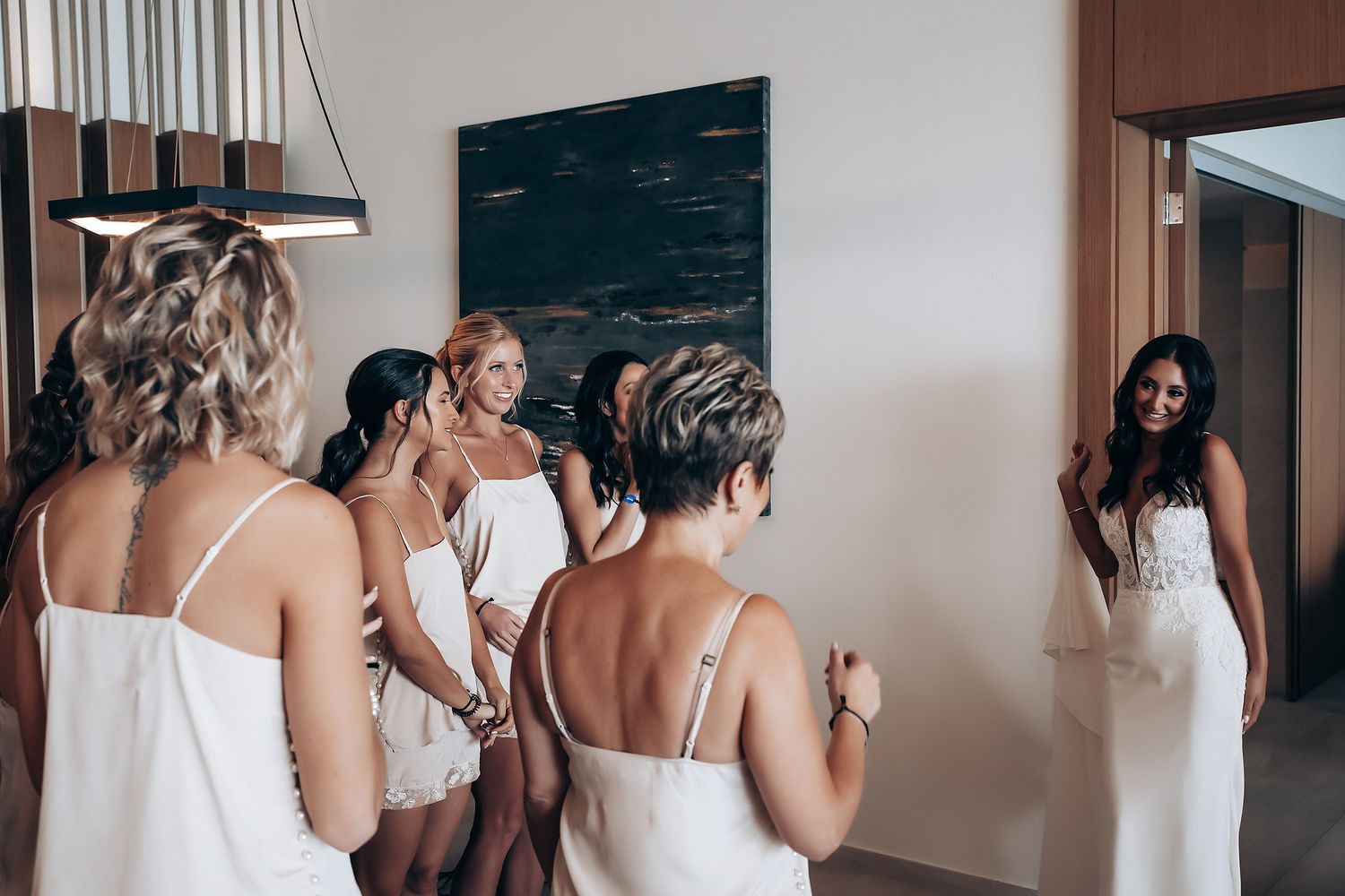 Wedding party getting ready in an elegant hotel room with natural lighting.