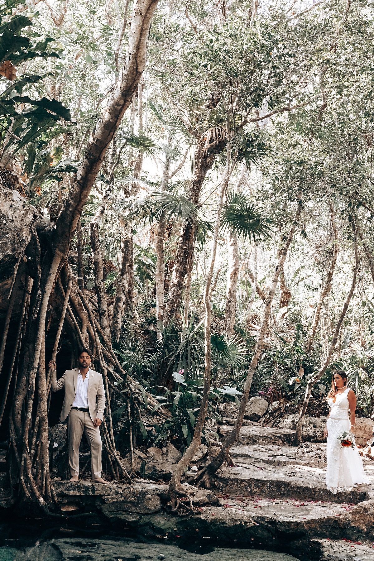 Intimate ceremony in serene tropical forest with natural light filtering through trees.