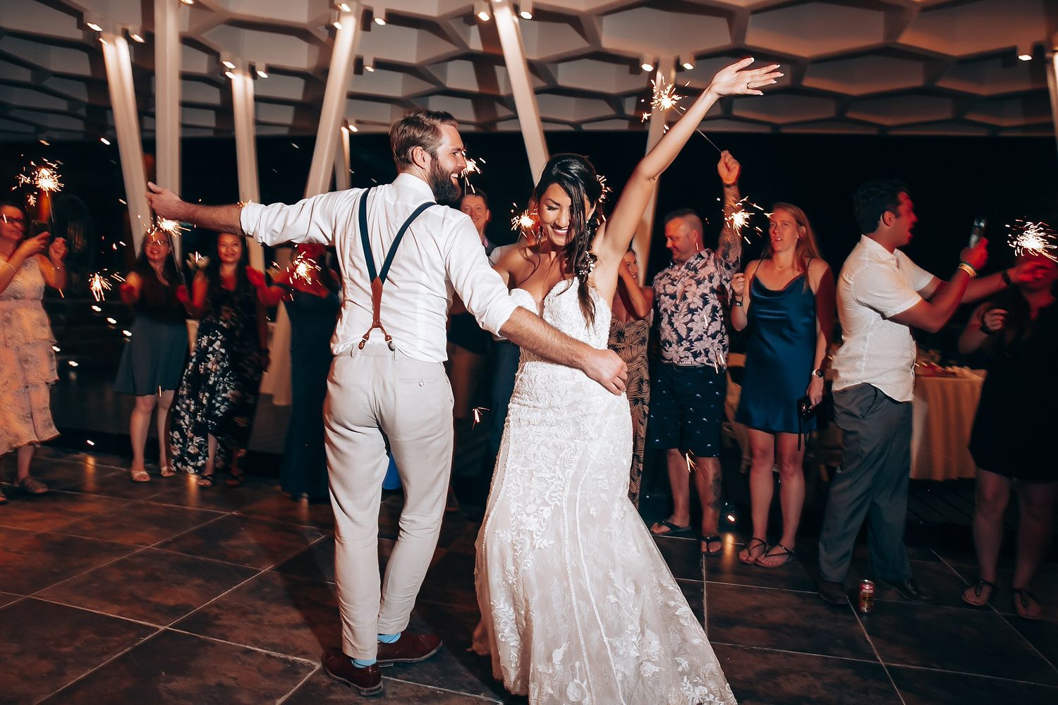 Wedding reception dance floor with couples celebrating under ambient lighting.