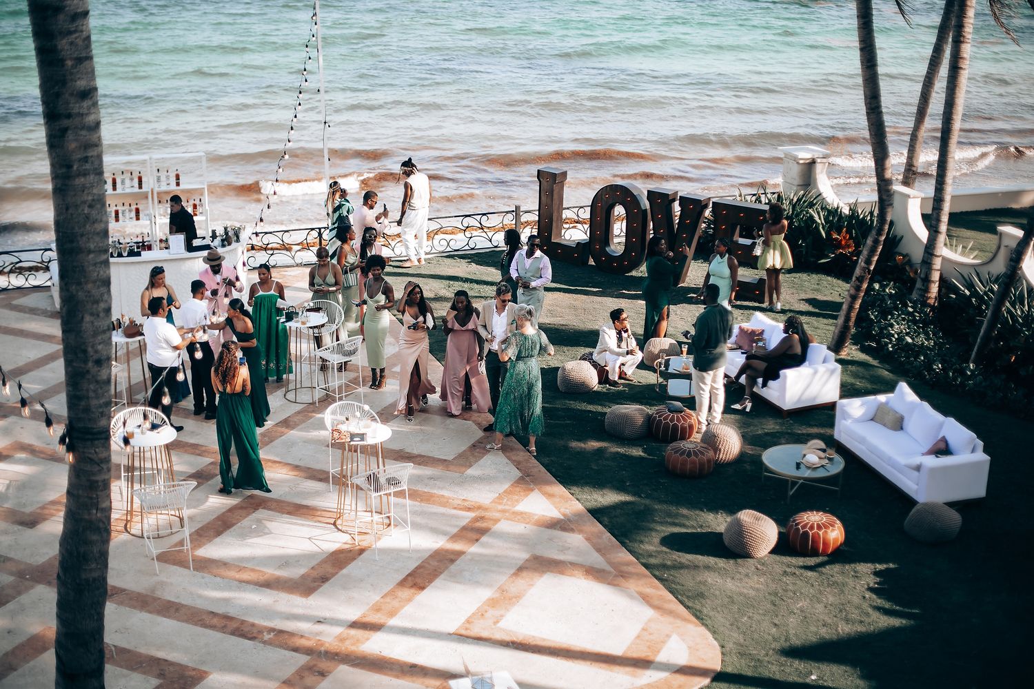 Beachfront wedding reception area with ocean views and tropical palm trees.