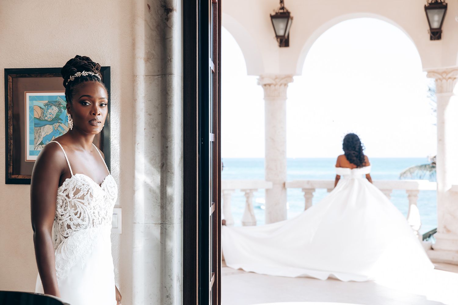 An elegant white wedding ceremony setup with columns and tropical palm trees in the background.