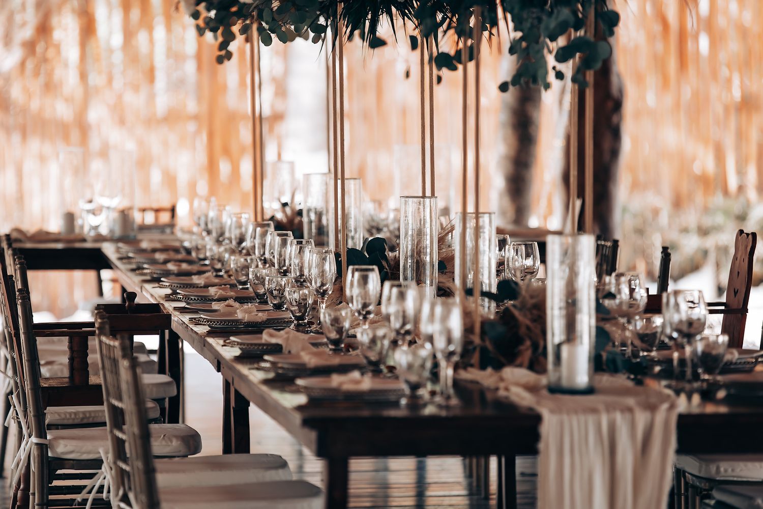Elegant wedding reception venue with crystal chandeliers and tables set with white linens and floral centerpieces.