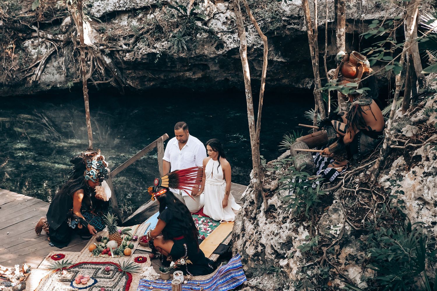 Group gathering for a traditional ceremony or ritual inside a natural cave setting.