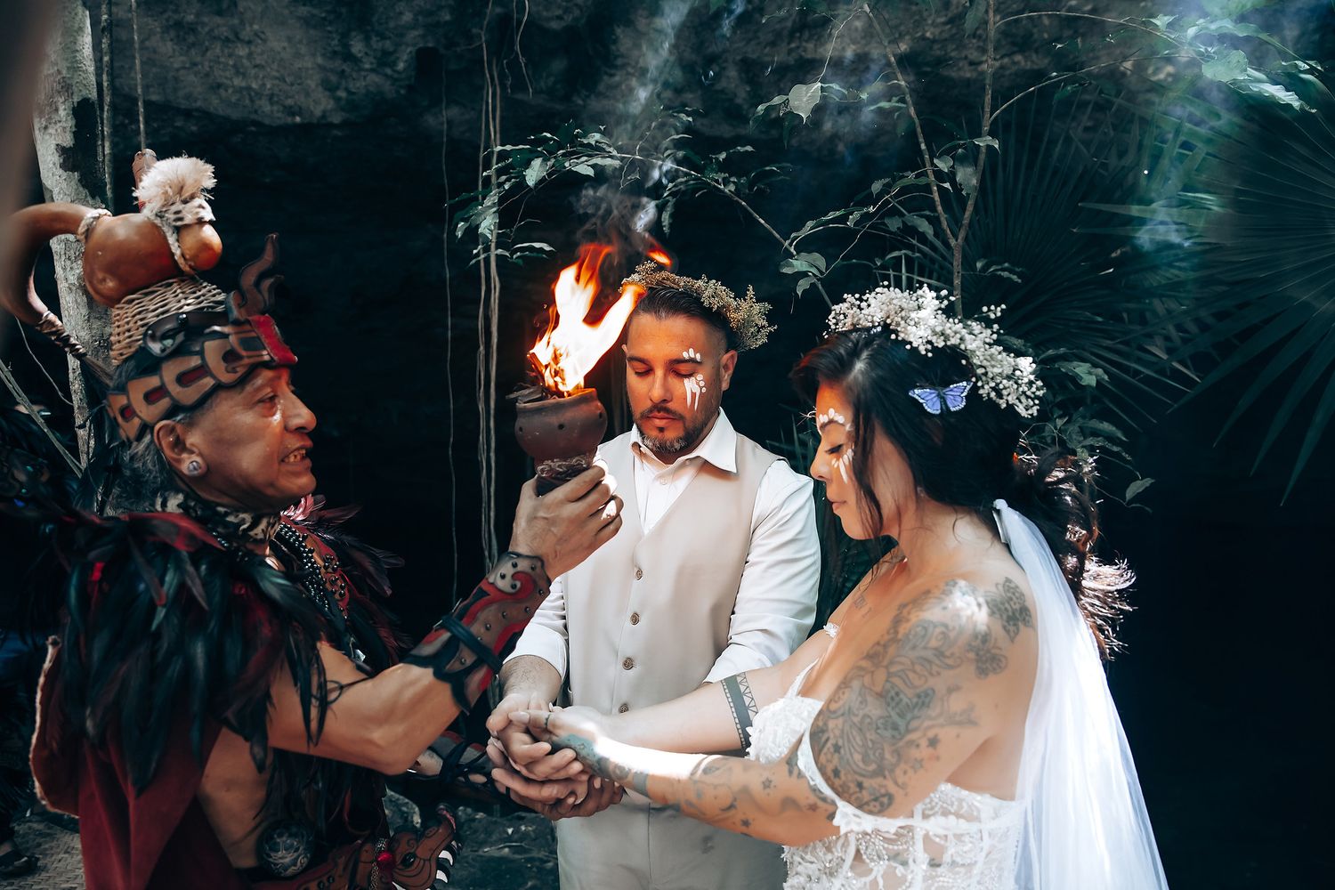 Intimate wedding ceremony with smoke effects in a natural cave setting.