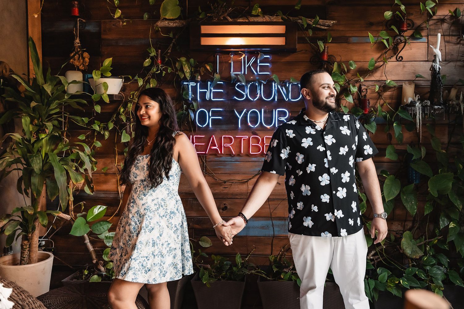 An evening proposal scene with illuminated neon signs and pool reflections.