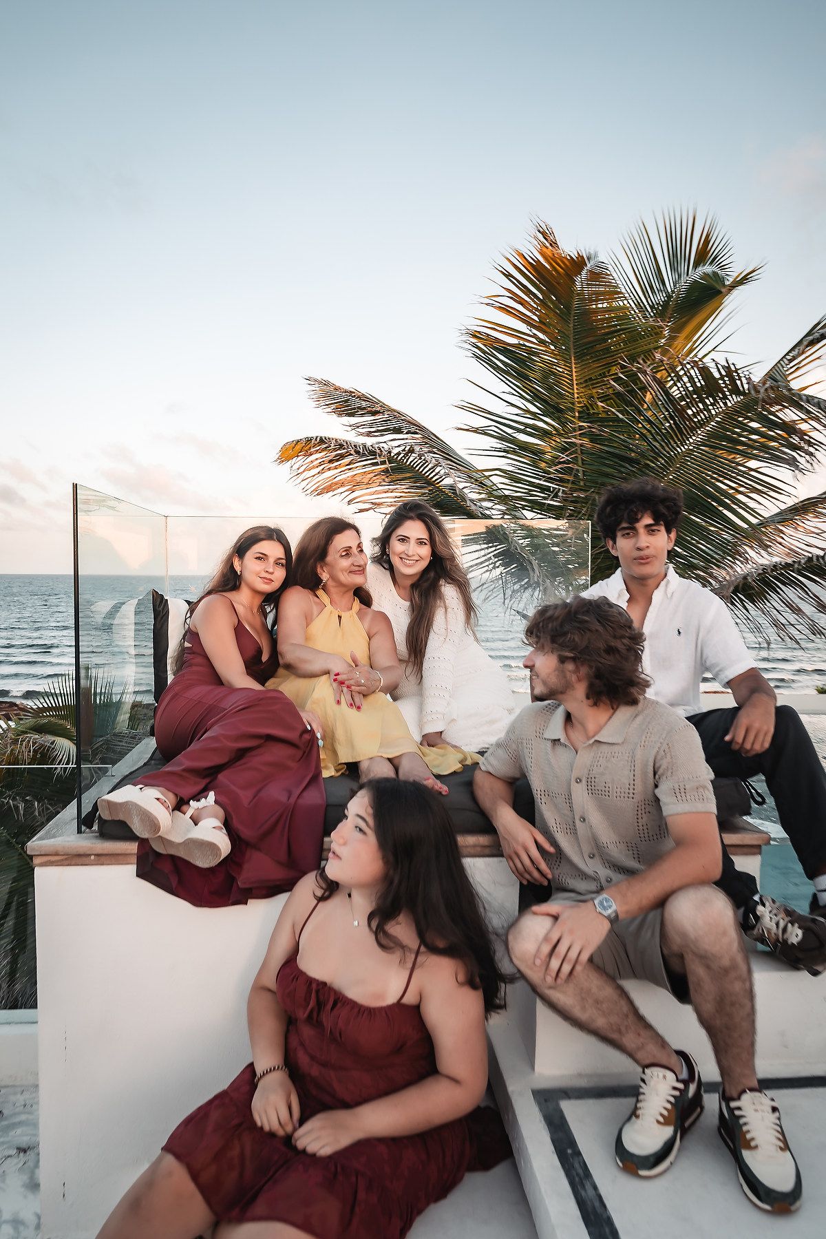 Group lounging and laughing together during a sunset beach photoshoot.