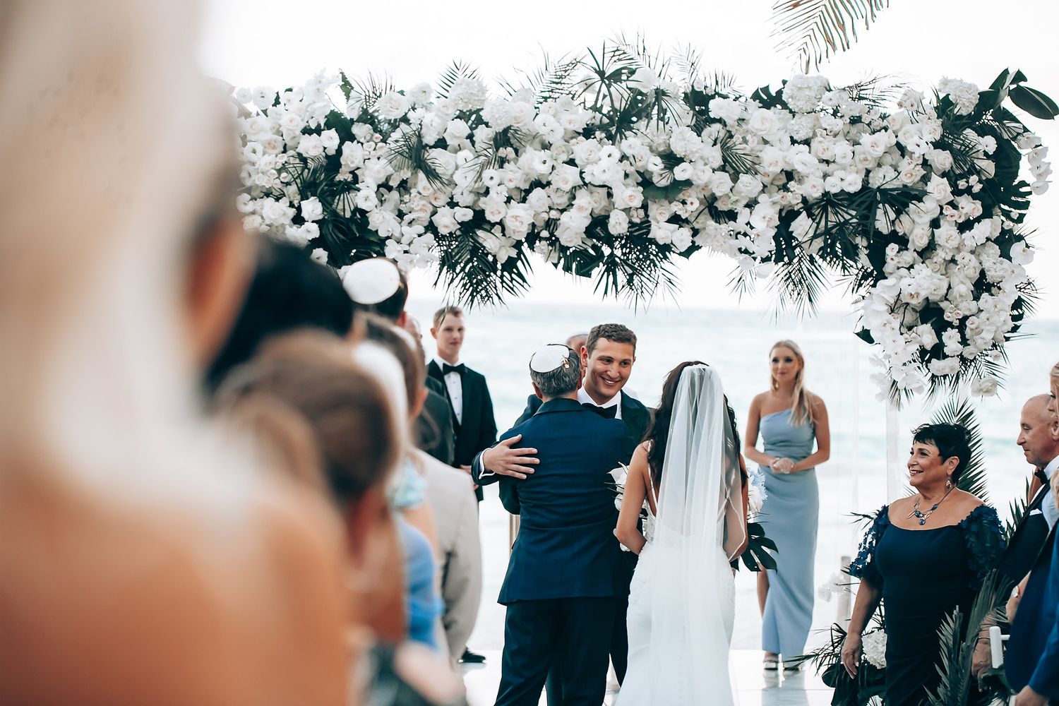 White floral arrangements and decor create a romantic ambiance at an outdoor wedding venue.