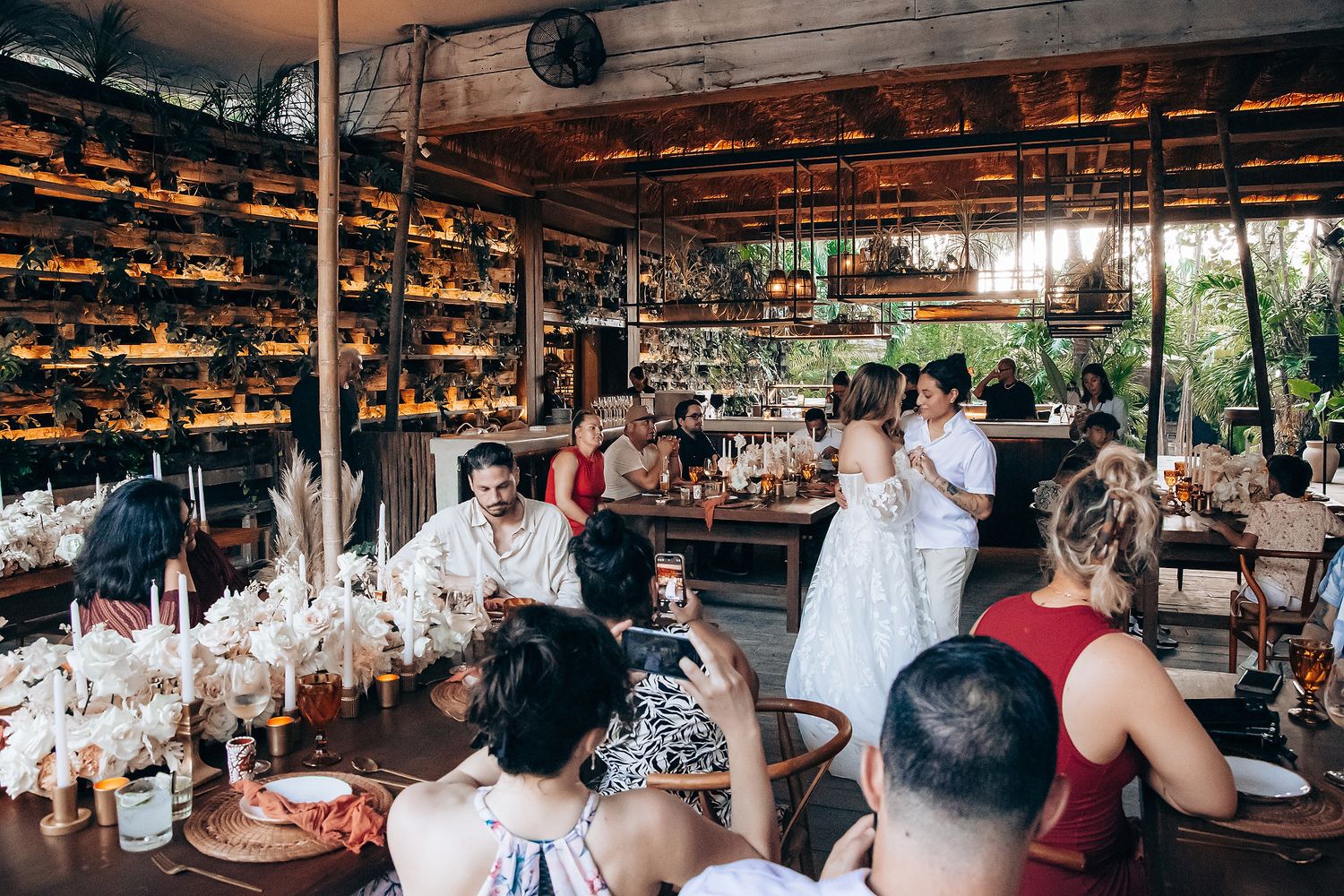 Wedding reception venue with rustic decor and natural lighting filtering through the structure.
