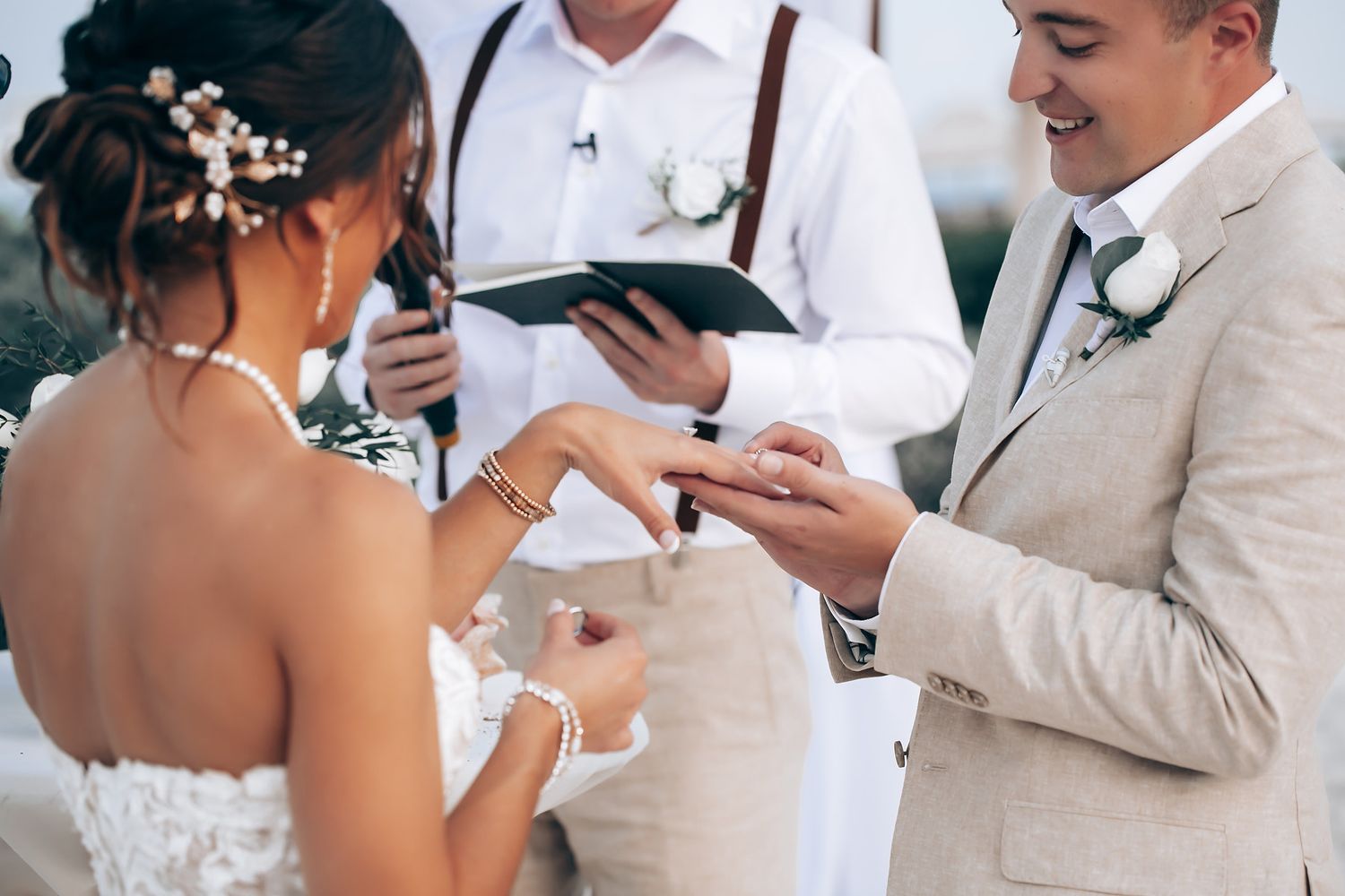 Wedding ceremony vow exchange under white canopy with emotional reactions.