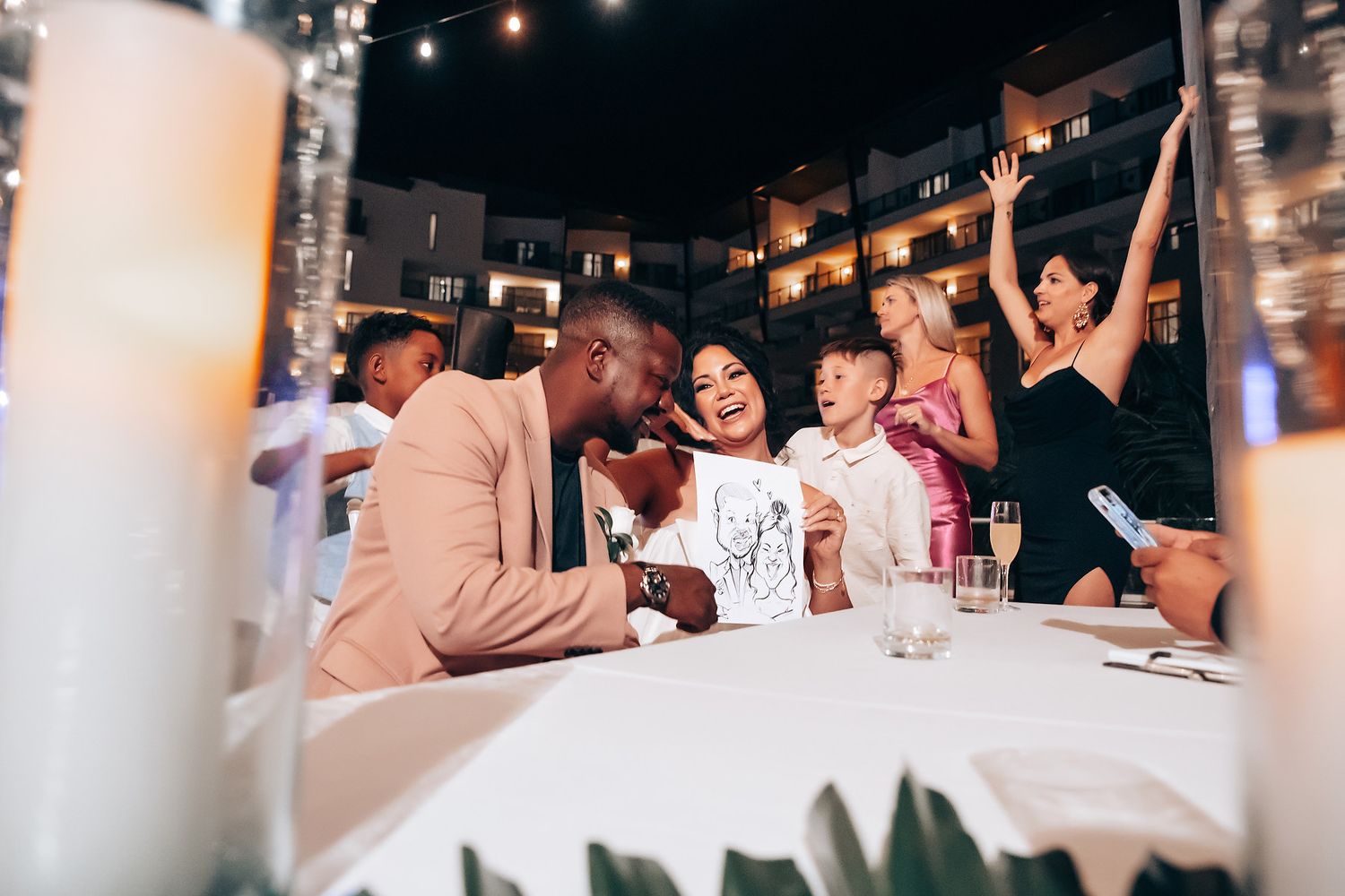 People celebrating and dancing together at a festive indoor party with ambient lighting.